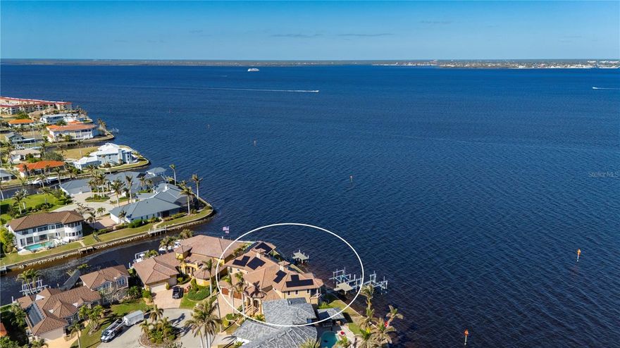 This Custom Home Presents an Exceptional opportunity to acquire a direct-Charlotte Harbor Residence comprising of four bedrooms, four full baths, attached oversized three car garage and an Executive Office, situated in Punta Gorda Isles, a Deed Restricted Community. Upon entering the residence, one is greeted by volume ceilings and expansive Waterfront views. The Great Room is furnished with a gas-burning fireplace, creating a refined atmosphere. The Spacious Kitchen is adorned with Center Island, New Quartz Countertops, Gas Range, top of the line appliances, a walk-in pantry, a pull out pantry and the design incorporates an eat-in kitchen bar and a spacious dining area adjacent to the kitchen. The primary bedroom occupies the entire West side of the main floor, offering serene views of the Waterfront, and the outdoor living area. This suite includes a mini-split system, large walk-in closet, leading to the ensuite bath, which features both a shower and a soaking tub and dual vanities. There is also a Guest Room, Guest Bath, Powder Room and Laundry Room on the main floor. There are two staircases leading to second level where you will find the Open family room with views Charlotte Harbor and overlooks the main living area, plus a Wet Bar with a Custom Lighted Countertop, great place to entertain. The second level also offers two more Guest Rooms and a full bath. Enjoy entertaining family and friends in the outdoor living area which includes a heated Saltwater Pool and a Separate Heated Spa, two gas firepits, along with an outdoor Kitchen, Covered Patio for Dining, and a lounge area all overlooking the Waterfront. Home has a Sol-Ark Solar system, two 120 gallon propane tanks, two tankless water heaters, a Generator Hookup, New Luxury vinyl flooring downstairs with the exception of the office, all bathrooms have been completely renovated and a new AC unit on the West side of the home, the attention to Detail is unsurpassed.  With 173Ft. of Direct Charlotte Harbor Waterfrontage, two Boat Docks, two Boat Lifts, Concrete Seawall you will have direct boating access to Charlotte Harbor and onto the Gulf of Mexico, World Class Boating and Fishing awaits. Plus, you will be within a short distance to the diverse attractions of Punta Gorda, Charlotte Harbor and all that Southwest Florida offers.  We invite you for a private tour of this remarkable Home.