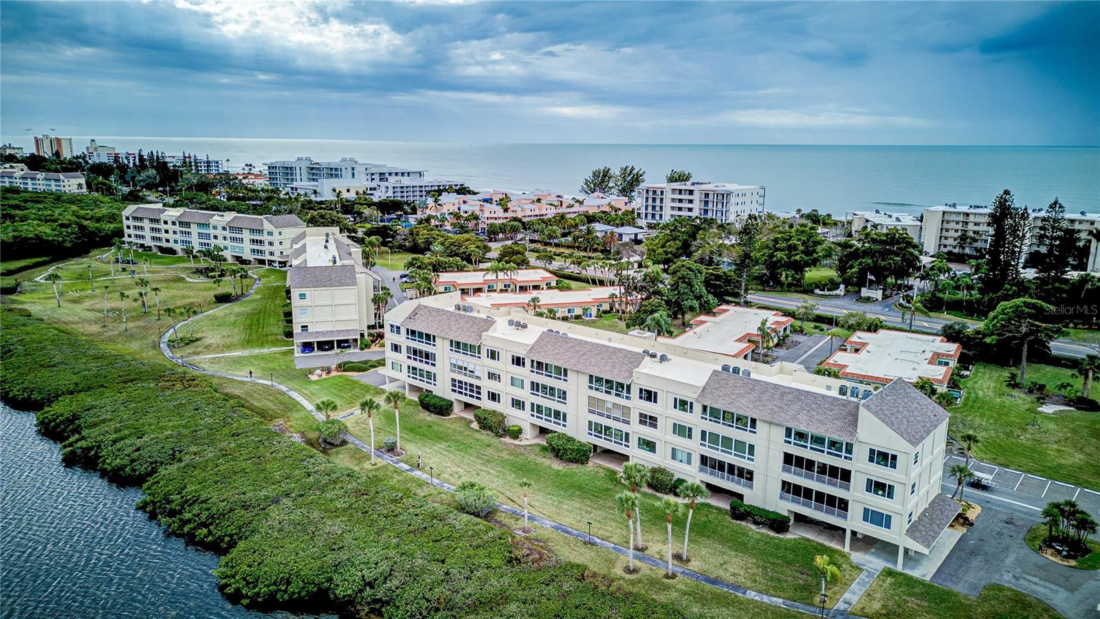 JAW-DROPPING WATER VIEWS! Revel & Relax as you experience amazing water views from every room of this inviting two-bedroom and two-bathroom condominium. Prepare to be enthralled by the mesmerizing beauty of the sparkling waters of Sarasota Bay, teaming with playful dolphins, graceful manatees, and the colorful spectacle of Florida's native birds. Witness spectacular sunrises, behold the magnificent moon while casting its illuminating reflection upon Sarasota Bay, all from this incredible place to call "home sweet home" or "home sweet second home." Lovingly maintained and move-in ready with brand new hurricane windows and a new roof in 2023. Additional highlights include a spacious walk-in master bedroom closet and an ample storage closet on the sun-filled Lanai/Florida room. A designated parking space and spacious owner’s closet (For all your beach toys and bicycles) is yours in the first level parking garage. “Pet Friendly” Windward Bay is a low-density residence and magical wildlife haven nestled mid Longboat Key, flourishing on 26 acres and graced with 1/2 a mile of waterfront trails for your enjoyment. Unparalleled resort-like amenities include 2 tennis/pickleball courts, 2 marinas with 28 boat & jet ski slips for a low monthly fee (waitlist), kayak racks, 2 heated pools, shuffleboard, bike racks, a clubhouse with kitchen, library, fitness room, meeting room, 2 saunas, and community fire pits/barbecues throughout the property. Steps away from stunning sunsets and the sugary sand beaches of The Gulf. (With one deeded beach access and two public beach accesses directly across the street.) For those seeking outdoor adventure, this property offers direct access to the water, making it perfect for boating, fishing, or simply enjoying a day on the water. With convenient access to Downtown Sarasota, St. Armands Circle, Bridge Street, Historic Cortez fishing village, championship golf courses, renowned restaurants, shopping destinations, and vibrant cultural attractions, you'll never have a shortage of entertainment options. The Windward Bay Association has been busy with a multitude of improvements and updates in the last few years including brand new roofs, resealing the buildings bayfront exteriors and painting of all the midrises in 2023/2024. Windward Bay is a financially healthy Condo Association with a proactive Board. The Milestone Inspection and Capital Reserve Study are complete and Monthly Condo Fees for 2025 were actually reduced. This property is not just a home, but a lifestyle filled with serenity and natural beauty. “Florida Gulf to Bay Living” at its finest. Schedule your private tour today and make your dreams a reality!