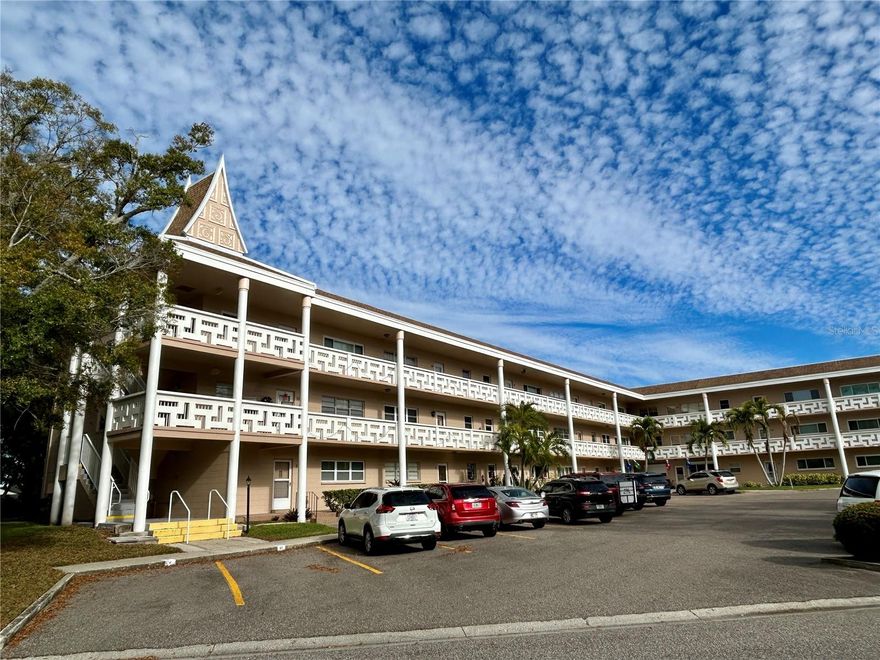 Enjoy the serene view of stunningly beautiful trees, including one that blooms twice a year, in this fully furnished, spacious, 2-bed, 2-bath, top floor end unit. A large, peaceful and quiet outdoor seating area is right outside your front door.  As you step inside you will feel like you're in a new home. The open concept floor plan has an expansive Dining Room/Living Room/Florida Room area with laminate flooring is surrounded by large, light and bright impact resistant windows providing plenty of natural daylight. The tastefully updated kitchen features soft close shaker cabinetry with convenient pull out shelves, granite counters and breakfast bar, tile backsplash, newer appliances and light fixtures, a pantry closet and ceramic tile flooring, making this kitchen a true delight for any home chef. Relax in the comfort and privacy of the 17? x 13? primary bedroom and updated en suite bathroom including a new, larger vanity and commode with a soft closure seat.  The walls have been freshly painted, the popcorn ceiling removed, and new door handles installed throughout the unit. The HVAC was replaced in 2021 and is inspected annually, and there are ceiling fans and a de-humidifier to keep you cool and utility costs favorable. The electric panel was replaced in 2022 and the water heater in 2024. Located in a vibrant 55+ community, you'll have access to a wide range of amenities designed to enhance your lifestyle. Enjoy two private golf courses (9 and 18 holes), two heated swimming pools, and two activity centers. Stay active in the remodeled cardio gym or engage in various community activities like fitness classes, dancing, clubs, cards, and billiards.  Pet owners will love the pet-friendly environment, featuring a fenced dog park and covered seating areas. Residents can also enjoy hobby studios and a woodshop for creative pursuits. The on-site Good Karma Café offers convenient snacks and drinks.  Conveniently located near beaches, transportation, shopping, entertainment, and fine dining, this condo perfectly combines comfort with accessibility. This property is being transferred by a leasehold estate deed, and association approval is required. If financing, a 35% down payment is necessary.  The seller is offering a $5,000 credit at closing towards installation of a washer and dryer. Schedule your showing today and enjoy the best in comfortable and convenient living!