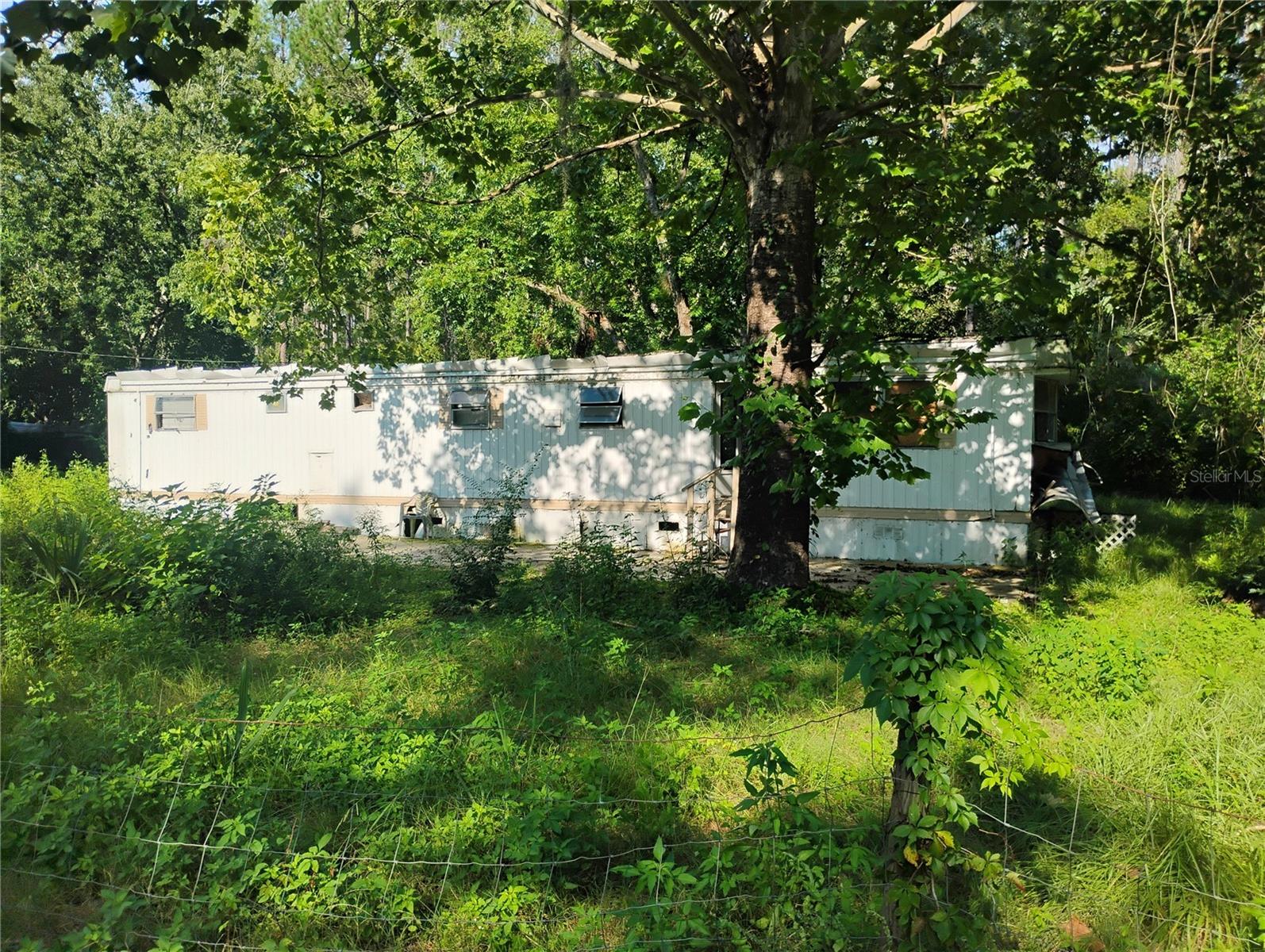 Attention investors! This is a total rehab project, or you could remove the existing home and place a new mobile home on the lot. The upside to this property is that it's already cleared, has a well and septic, on a paved road, and impact fees are paid, saving lots of money. It's also not in a flood zone. Conveniently located just off Hwy 40, making it a short trip to Ocala Silver Springs. Just on the edge of the Ocala National Forest, making it a nature lover's paradise. Call for more information.