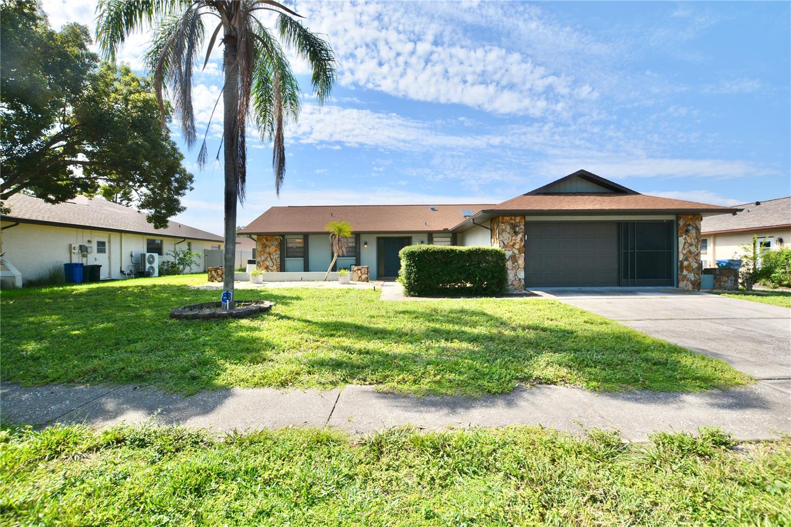 Welcome to this 1,682 sq ft, three-bedroom, two-bathroom pool home in the charming ORCHID LAKE VILLAGE community. This home boasts a fully renovated kitchen with wood cabinets, quartz countertops, a cooking island, and stainless steel appliances. The Updated Primary en-suite bathroom features a stand-alone shower, dual vanities, decorative tile and a large walk-in closet. Recent upgrades include a 2019 roof, 2024 HVAC, and a newer water heater, pool screen enclosure: 2022, pool pump: 2019, pool light: 2025. Enjoy vaulted ceilings and a stunning kitchen skylight. The open-concept layout seamlessly connects the kitchen, family, and dining areas, perfect for entertaining. French doors open to a bonus room overlooking the screened-in pool. The split floor plan offers spacious, functional bedrooms, with a convenient laundry room off the kitchen and ample storage, including a backyard shed. Close to US 19, Suncoast Parkway and many shopping and dining options.