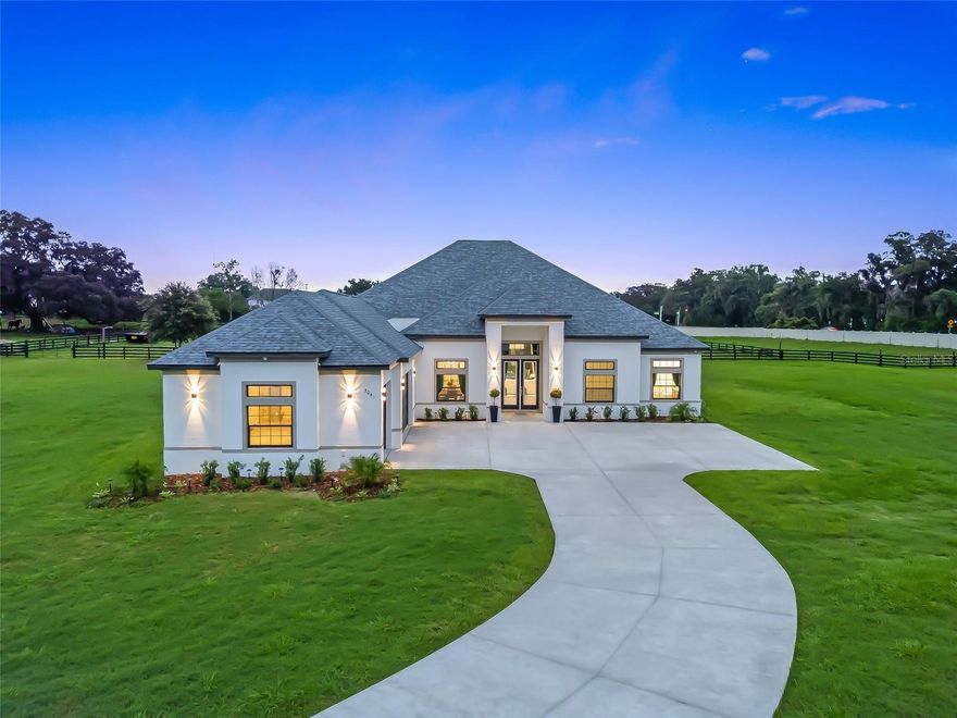Welcome to 7041 NE 22nd Court Rd — a brand-new, custom-built estate gracefully situated on one of the largest parcels within the exclusive, gated community of SummerHill. Tucked behind a private, solar-powered entry gate, this elegant 4-bedroom, 3-bathroom home with a dedicated office was thoughtfully designed for both luxury and functionality. A 14-foot wide custom concrete driveway, expanding to 17 feet from post to post, effortlessly accommodates trucks and trailers, while the upgraded 8-foot garage doors add to the home's grand approach.

Inside, soaring 13+ foot ceilings and oversized windows flood the living spaces with natural light and picturesque views. Built with insulated concrete block construction and a high-efficiency HVAC system, the home offers exceptional energy savings and year-round comfort. The estate features a stunning 7-stall Saratoga-style barn crafted with imported bamboo, complete with automatic waterers, a wash stall, and two fully fenced paddocks—perfect for equestrian enthusiasts.

Additional highlights include a hardwired CCTV security system for peace of mind, newly designed landscaping accented by solar lighting and upgraded gutters, and two 50 AMP hookups ready for a generator. The property is backed by a one-year builder’s warranty from the date the Certificate of Occupancy was issued. Ideally located just minutes from Ocala’s premier equestrian venues, golf courses, and lifestyle amenities, this home offers a rare opportunity to experience high-end country living in one of Central Florida’s most coveted locations. Some images have been virtually staged to help envision the full potential of this extraordinary home.