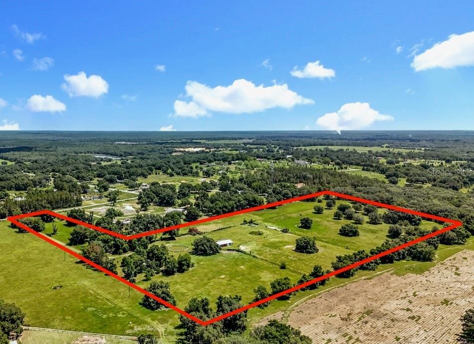 PRICED TO SELL! This estate can be divided into four 5 ACRE LOTS for a family compound if needed. Nestled on 22.5 picturesque acres, 41204 Emeralda Island Rd is a dream property for horse enthusiasts, trainers, or investors. The property boasts lush pastures and two separate entrances, offering endless possibilities for private use, an equine business, or sub-leasing. At the heart of the facility is a thoughtfully designed center-aisle barn featuring 8 spacious matted stalls, each with its own electrical outlet for fans or lights and a 40 Amp RV electrical connection. Flexible removable dividers allow for larger stalls or foaling stalls as needed. The barn also includes two wash racks/tack-up centers, cross ties, an oversized tack room/feed room, and a welcoming sitting area — perfect for relaxing after a day with the horses. A separate, oversized, cleared and fenced pasture is located off of of the secondary entrance already equipped with a lean-to, run-in stall, perfect for easy sub-lease conversion OR quarantine stalling for new equine additions. While value is in the land, the manufactured home (30 year metal roof) on site provides established well, septic, electric, and associated impact fees paid. Located just one hour from the World Equestrian Center (WEC), this versatile property combines functionality, comfort, and prime location — ready to bring your equestrian vision to life.