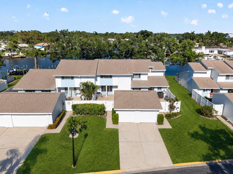 Perfectly positioned within the highly coveted waterfront enclave of Mariners Pass, 6497 Cape Hatteras Way NE #3 delivers an extraordinary blend of refined coastal luxury, designer-level finishes, and breathtaking panoramic water views that feel more reminiscent of a private waterfront residence than a traditional townhome. Framed by tranquil waters and daily sightings of dolphins and manatees directly from your backyard, this is the type of residence that transforms everyday living into a permanent waterfront retreat. Spanning two thoughtfully designed levels, this beautifully reimagined 3-bedroom, 2.5-bath residence immediately captivates with its seamless indoor-outdoor flow, sophisticated design aesthetic, and sweeping water vistas that serve as the backdrop to nearly every living space. A charming front courtyard creates a warm and private arrival experience, while the covered waterfront patio offers the ultimate setting for morning coffee, sunset cocktails, and effortless entertaining against a constantly changing waterfront canvas. Inside, the residence has been elevated with an impressive collection of luxury upgrades and designer finishes throughout. The stunning kitchen was curated with both style and functionality in mind, featuring a premium Samsung Café appliance suite, sleek quartz countertops, seamless full-height backsplash, ceiling-height soft-close cabinetry, recessed LED lighting, and carefully selected luxury fixtures that create a clean yet elevated modern coastal feel. Rich LVP flooring flows throughout the residence, complemented by crown molding, designer lighting, updated tile work, new vanities, new toilets, and meticulously selected plumbing fixtures that collectively create a polished and cohesive living experience. Expansive PGT impact-rated windows and doors flood the home with natural light while framing the incredible panoramic water views from nearly every angle. Major system updates provide additional peace of mind, including a 2025 Goodman HVAC system and a 2025 40-gallon State hot water heater. A dedicated ground-floor laundry room, detached one-car garage, and abundant storage further enhance the home’s functionality without compromising its elevated aesthetic. Set within one of Northeast St. Petersburg’s most desirable waterfront communities, Mariners Pass offers a uniquely tranquil lifestyle just moments from downtown St. Petersburg, waterfront parks, marinas, award-winning dining, and the vibrant energy of the city. For the most discerning buyer seeking turnkey waterfront living with designer finishes, captivating views, and an unmistakable sense of serenity, 6497 Cape Hatteras Way NE #3 is truly exceptional.