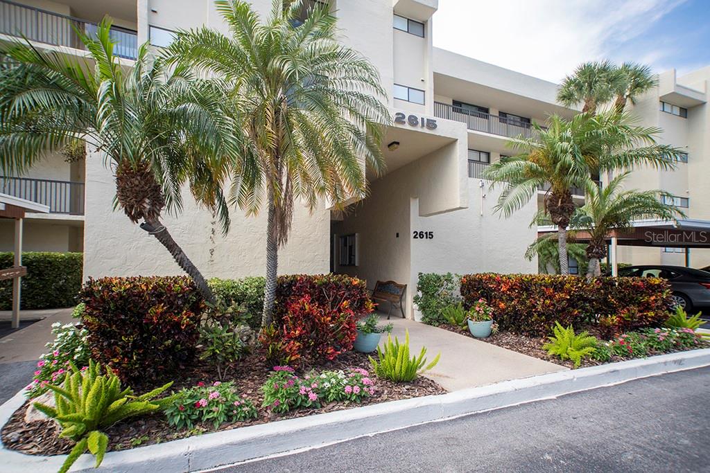 Enjoy ultimate convenience in this beautifully remodeled 2-bedroom, 2-bath ground-floor condo with easy access from your car to the front door—and just steps to the sparkling community pool. Thoughtfully updated throughout, this unit features hurricane-rated impact windows, including the expansive picture window that brings natural light into the living room from the porch. The sleek wood-look ceramic tile flooring adds both style and practicality, perfect for Florida living. The kitchen is a standout with crisp white cabinetry, premium MSI Stellar Gray quartz countertops made with natural materials, a striking glass block backsplash, and stainless steel appliances. Both bathrooms have been completely and beautifully renovated with modern and tasteful finishes. A private laundry room just across the hall serves this unit exclusively, and you'll love relaxing on the screened porch. This condo is the perfect blend of comfort, style, and low-maintenance living—don’t miss it! Covered parking will protect your vehicle year round. And you are virtually steps to the pool and recreation area, even accessible from your screened porch. All of this plus lush landscaping as you drive through the community, a golf course and restaurant with full bar open 7 days a week, guarded entry and more and you have the Paradise known as Cove Cay.