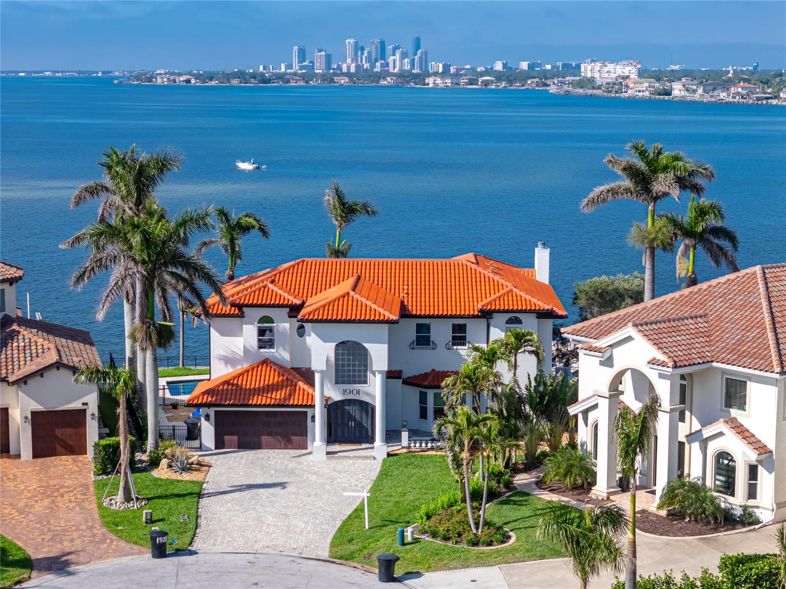 One of the best views in the bay! Enjoy unimpeded, panoramic sights of the Downtown St. Pete skyline and the Skyway Bridge beautifully lit at night, all from the premier Venetian Isles neighborhood on the most coveted street—Carolina Avenue NE. This property experienced no flooding from hurricanes Helene or Milton and has an assumable flood policy for under $1900 a year!
This exceptional 4-bedroom, 4-bathroom home with a dedicated office and 2-car garage offers everything you could want in waterfront living. Thoughtfully updated throughout, it features a newer roof, HVAC systems, Raypak gas pool heater, Jandy variable-speed pool pump, and a pool finish in excellent condition. Additional upgrades include newer soffit and fascia, a custom garage door, a paver driveway and backyard patio, and a newer dock with a 16,000 lb boat lift. The seawall spans an impressive 138 feet of Tampa Bay frontage—one of the largest in the area!
The home’s layout is both spacious and versatile, with an open-concept kitchen and living room, a formal dining area with an adjoining living space, and a third living area currently used as a game room. The expansive primary suite boasts a luxurious en-suite bath and a large walk-in closet. Enjoy generous outdoor living with patios on both levels and newly refreshed landscaping in both the front and back yards. Furniture and art on walls will convey with a full price offer.