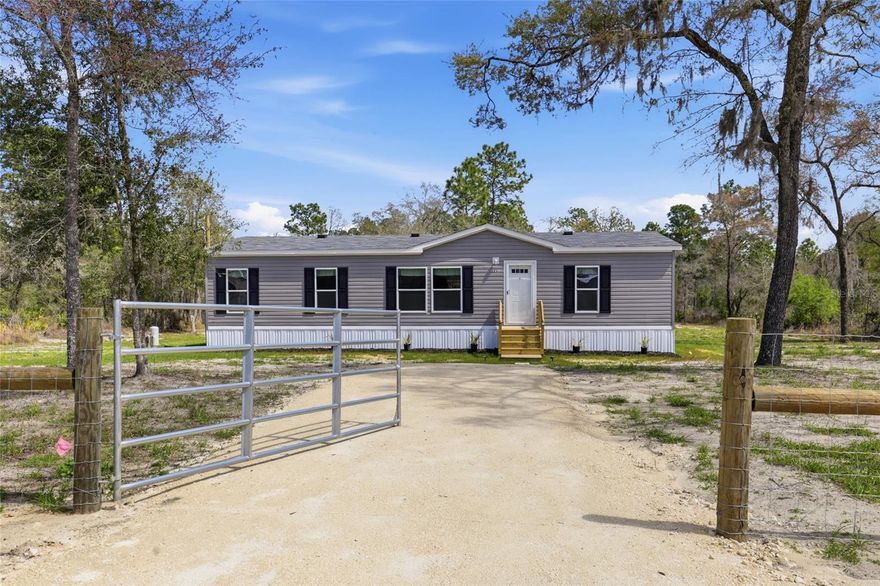 Brand new 2026 Live Oak manufactured home on 1.25 acres in Levy County! If you’ve been searching for homes with land near Williston or Morriston, Florida, this beautiful 3 bedroom, 2 bathroom home in the heart of Florida horse country offers the space, privacy, and peaceful North Central Florida lifestyle buyers are looking for. This new 1,568 square foot manufactured home in Levy County features a desirable split floor plan, with the primary suite located on one end of the home and the guest bedrooms on the opposite side for added privacy. The bright and open living area allows for abundant natural light, creating a warm and welcoming atmosphere throughout the home. The kitchen features attractive dark wood cabinetry, durable vinyl flooring, and a spacious dining area perfect for everyday living. The living room and bedrooms offer comfortable carpet flooring, creating a cozy feel throughout the main living spaces. The primary suite includes a large step-in shower, a spacious bathroom layout, and a large walk-in closet conveniently located off the bathroom. Both guest bedrooms also feature walk-in closets, and the guest bathroom includes a solid one-piece fiberglass shower designed for durability and easy maintenance. Situated on a nicely cleared 1.25-acre lot in Levy County, the property offers a beautiful blend of open space and scattered trees for natural landscaping. The land has been freshly seeded with grass and includes brand new fencing across the front and back of the property, along with a gated entrance and limerock driveway for easy access. This property is ideal for buyers searching for homes with acreage near Williston FL, homes with land near Morriston Florida, or new manufactured homes in Levy County. Enjoy the peace and quiet of country living in North Central Florida while still being conveniently located just 45 minutes to Ocala and 45 minutes to Gainesville. Located in the heart of Florida’s horse country, this property offers easy access to equestrian farms, outdoor recreation, and the charm of small-town living while still being within driving distance of major amenities. If you’ve been searching for affordable homes with land in Levy County, new homes near Williston or Morriston FL, or manufactured homes on acreage in North Central Florida, this beautiful Live Oak built home is one you won’t want to miss.