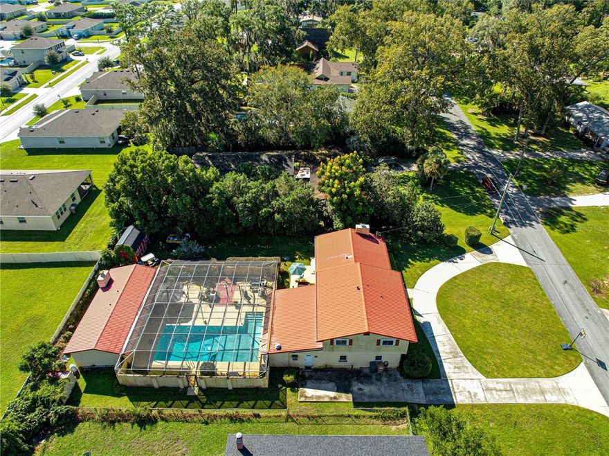 If you are looking for a one-of-a-kind home with tons of space for a large family or multi-generational living, then this is the home you have been looking for! This spacious and stylish Mid-Century Modern split-level home with over 3,000 sq ft of living space! This one-of-a-kind Florida retreat features a durable red metal roof, circular driveway, and a screened-in pool perfect for year-round enjoyment.  Inside, you will love the updated kitchen with butcher-block countertops, stainless steel appliances, and white and navy cabinetry that add a great farmhouse touch. The bright, open living area includes hardwood floors, a cozy brick fireplace, and built-in shelving for added charm and storage.  The built-in storage/seating around the dining table is perfect for family meals together.  Multiple living and entertainment spaces throughout the home provide incredible versatility — including a large bonus room with built-in grill and pool access, a dedicated media room with a wet bar, and flexible areas ideal for a gym, office, or guest suite. Enjoy the private screened lanai and sparkling pool surrounded by mature landscaping. Bedrooms are spacious, and bathrooms feature unique retro details ready for your personal touch. There is even a detached in-law suite that features a living area, kitchen, a large bedroom with cedar closets and bath, which is perfect for live-in parents or adult kids wanting their privacy.  The side deck creates yet another private cove for a quiet evening or entertaining.  There is even a hot tub included! There are so many cool features to this home!  Located in a well-established neighborhood close to shopping, dining, The Appleton Museum, Ocala Civic Theater, and Silver Springs this home offers character, space, and functionality — the perfect blend of classic design and Florida lifestyle!  Schedule your private tour today!