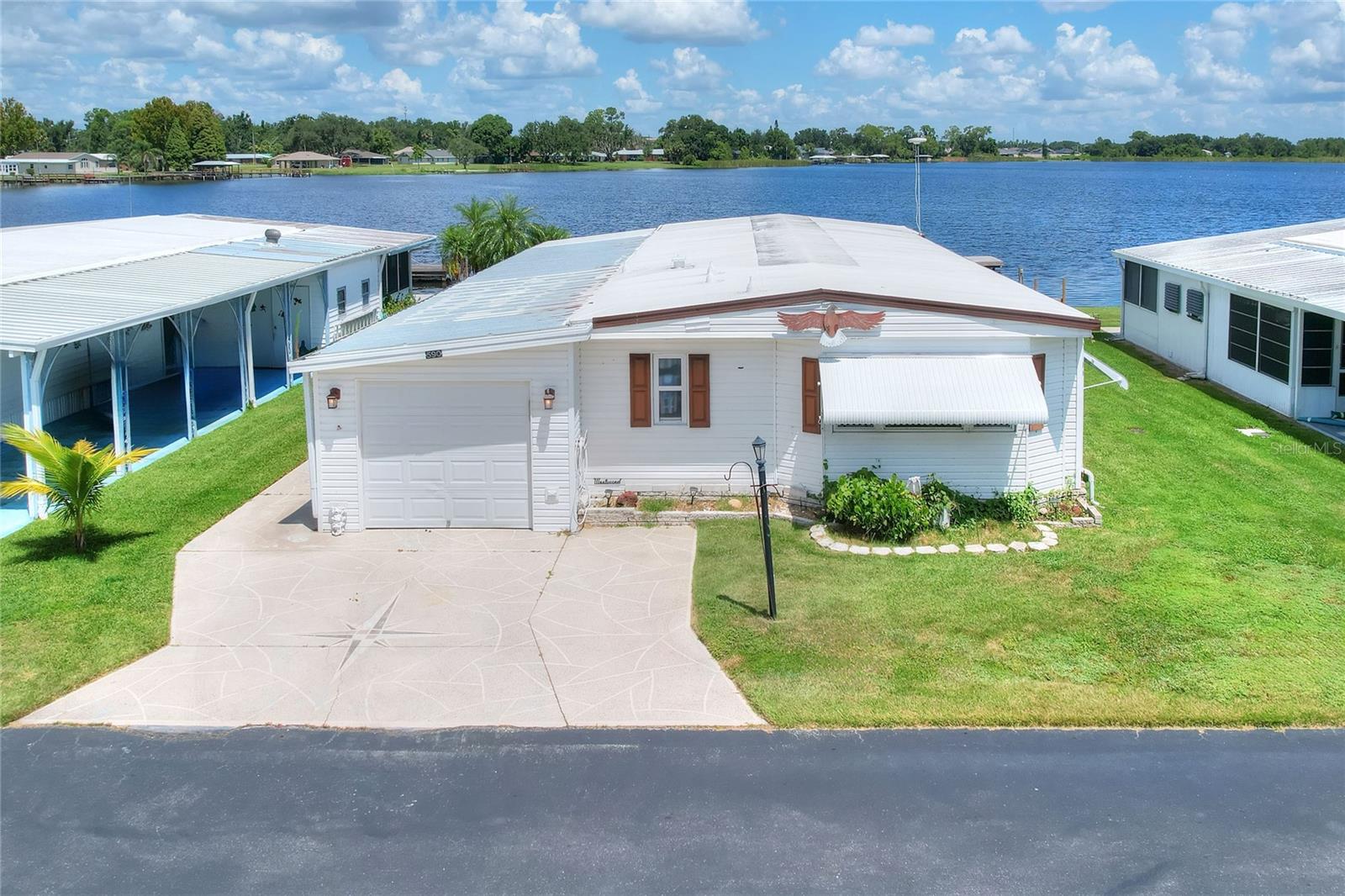TRUE LAKEFRONT with DOCK. Ideal Central Florida location along the shoreline of the Lake Hamilton 2,200 acre Chain of Lakes. Lake Region Mobile Home Village is a Gated 55+ Resident Owned and Operated cooperative of over 600 homes situated on over 200 acres of land featuring all the community amenities to enjoy. If you are looking for a quality Florida Active Retirement lifestyle, look no further. Perfect for a winter getaway or year-round living. FULLY FURNISHED. This home has received a number of updates over the past few years Vinyl Lap Siding, Double-pane windows PVC plumbing, Wood, Laminate, Tile flooring, Roof replacement. Appliances are showing some age. In addition to the garage is approximately 420 sf storage and workshop space The co-op share is also included for your lot valued at $60,000 with the share transfer also including an approximately 1/600th+ of the development and amenities. The HOA fee includes Water/Sewer, Trash, SPECTRUM Internet and Basic Cable TV, Use of Clubhouse, Heated Pool, Fitness Cener, Pickel ball, Tennis, Horseshoe court, 3 on 3 Basketball court, Tree shaded Picnic and Event Park and more. Quick response and fast closing available, Maximum 2 residents both age 55+, No pets allowed. (All buyers are subject to HOA background and credit approval minimum 700 score). Select lender third party financing may be available.