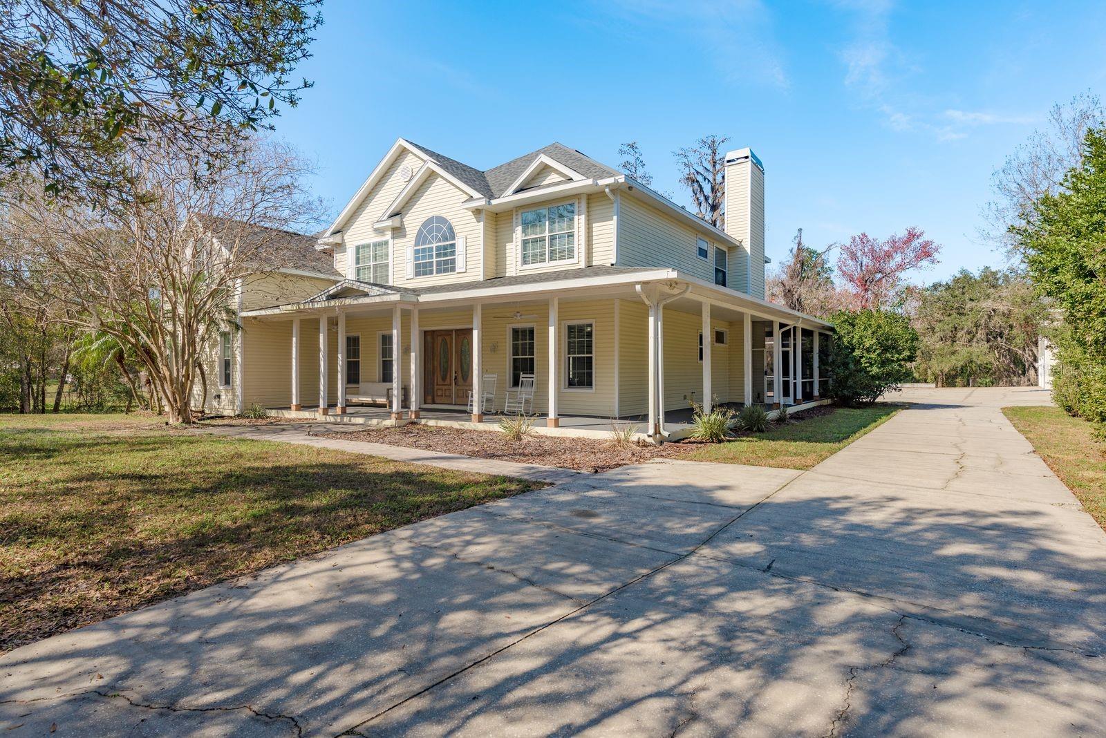 One or more photos have been virtually staged. Welcome to this stunning estate in Oak Ridge, set on 1.69 acres in the sought-after Trinity area. Offering the perfect blend of country tranquility and modern convenience, this exceptional home provides ample space to roam while being minutes from top-rated schools, shopping, dining, medical facilities, golf courses, and beaches. Originally built as the personal residence of a master builder, this home exemplifies superior craftsmanship and meticulous attention to detail. Spanning 5,991 square feet, it features five bedrooms, five full baths, and two half baths, creating a seamless balance of elegance and comfort. Recent updates ensure peace of mind, including a new roof in 2023, newer A/C units within the last three years, a 30kW Generac generator with a 500-gallon underground tank (inspected and working perfectly), a water treatment system, and a full electrical and septic inspection in 2024. A long driveway and inviting wraparound porch set the stage for this remarkable property. Adjacent to the main home, a detached four-car garage includes a spacious 1,181-square-foot studio apartment above, complete with a kitchenette and bathroom. This versatile space is ideal for guests, in-laws, a home office, a game room, or rental income. Stepping through the freshly stained double entry doors, the grand two-story foyer welcomes you into a warm and inviting home. Hardwood floors flow throughout the main living areas, leading to a spacious family room with a striking stone wood-burning fireplace. The open-concept design seamlessly connects to a chef’s dream kitchen, featuring abundant cabinetry with decorative glass accents, a large island, a walk-in pantry, and a butler’s pantry leading to the formal dining room. Whether hosting intimate gatherings or grand celebrations, this home is designed for entertaining. A casual dining area by the French doors offers beautiful views of the pool and backyard. The main level also boasts a luxurious primary suite with French doors opening to the pool and hot tub, along with two oversized walk-in closets and a spa-like en-suite bathroom. An additional downstairs bedroom, which could serve as a home office, and a half bath complete this level. Up the grand staircase, the second floor offers another large primary suite with a private en-suite bathroom, as well as two additional bedrooms with ample closet space, one of which includes its own en-suite bath. A spacious gym, designed to be easily converted into another bedroom if needed, leads to a private office area. The loft space, complete with a laundry chute, provides endless possibilities as a media room, game room, or play area. Go back downstairs using the second staircase leading to the kitchen—super convenient. This home is made for outdoor living, featuring an expansive paver pool deck, a resort-style pool with a waterfall, and a relaxing hot tub, all set against the backdrop of mature trees and abundant wildlife. A custom-built treehouse, crafted with the same exceptional quality as the home, offers a fun retreat for children. At the back of the property, a private freshwater creek provides the perfect spot for bass fishing. With plenty of space for boats, RVs, and all your recreational toys, this home truly offers the best of country living with modern conveniences just minutes away. Don’t miss the opportunity to experience this extraordinary property—schedule your private showing today!