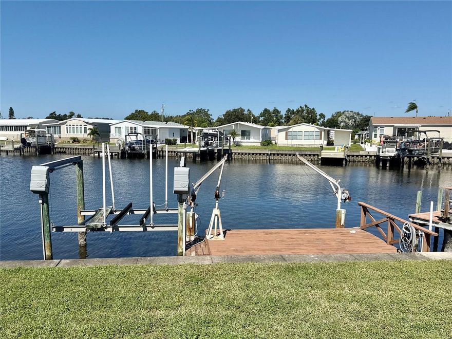 With more than 1,350 sq. ft of living space, this 3 bed/3 bath waterfront property is a must see! The home has been totally remodeled and feels like a single family home! There are two master suites with full baths set in split bedroom plan for privacy plus a roomy third bedroom with guest bath. The living room/dining/kitchen area are in an open floor plan and look out to the air conditioned Florida room with slider to backyard, dock and lift. Washer and dryer are off the Florida room for ease of use. Large shed with garage door to store golf cart, tools, bikes and boating equipment. Features of the home include wood-look luxury vinyl waterproof flooring throughout, drywall throughout, mostly newer windows, 2025 plumbing and electric, 2025 roof with 2025 two-car carport, beautiful kitchen with quartz countertops, wooden cabinets, stainless steel appliances including stove, dishwasher, range, refrigerator and microwave; two baths have walk-in showers and third bath has tub and shower combo. 2025 hot water heater. Home tented in 2023. Paid flood insurance through Nov. 2027. New HVAC system that has been recently serviced. Saltwater canals are on navigable water to Tampa Bay with no bridges. Dolphin and manatee play at your dock. This is the retirement waterfront dream home! Price includes share for the lot and ownership in the co-op plus the dock and lift! Low monthly maintenance fee of $380 includes water/sewer/trash pick up/lawn maintenance/ 24 hr manned gate/private streets/seawall maintenance and all amenities including heated pool, clubhouse, fitness center, billiards and so much more! Home is located in the premier 55 and older dog friendly community of Americana Cove. Located only 10 mins to downtown St. Petersburg, 5 minutes to 4th Street grocery, restaurants and shopping and 20 mins to two airports. 2 dogs or cats up to 35 pounds are welcomed! Don't miss out! Come see the best kept secret in St. Pete!