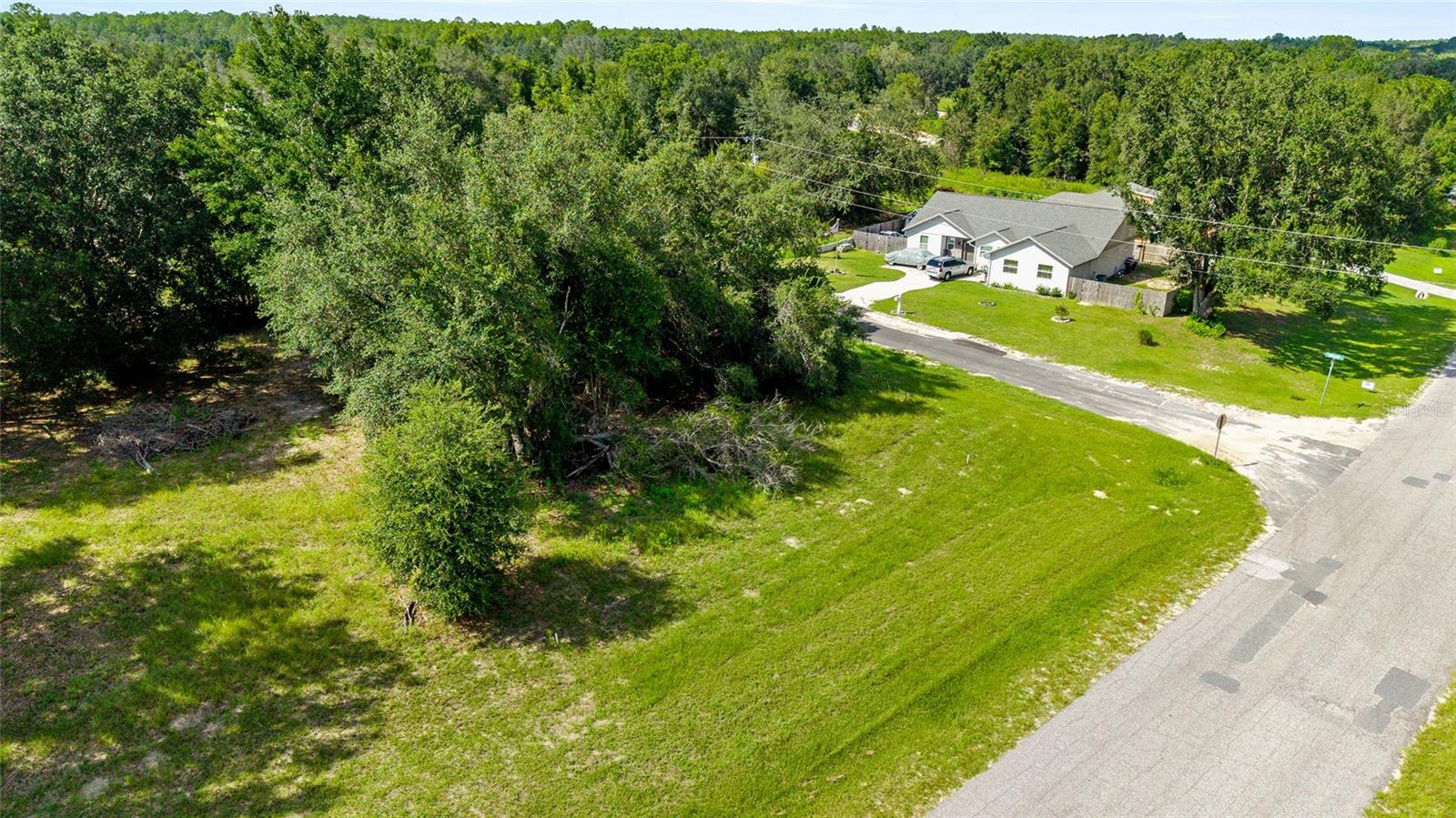 Fractional Ownership. Corner Parcel with excellent elevation and partially cleared leaving a few feature trees. High & Dry!!! Citrus Springs is Deed Restricted to protect your investment, but NO HOA and NO HOA FEES. This parcel is located on a paved road in an area with new construction homes. The Citrus Springs community is a short 10 min drive to Dunnellon and the sparkling Rainbow River for kayaking, snorkeling, swimming, tubing, fishing and much more. Plus you'll enjoy being only 3 blocks away from a trailhead for the 46-mile-long Withlacoochee State Trail - one of Florida's longest paved "rails to trails"! Two adjacent parcels facing E. Citrus Springs Blvd are also available for purchase: OM709559.