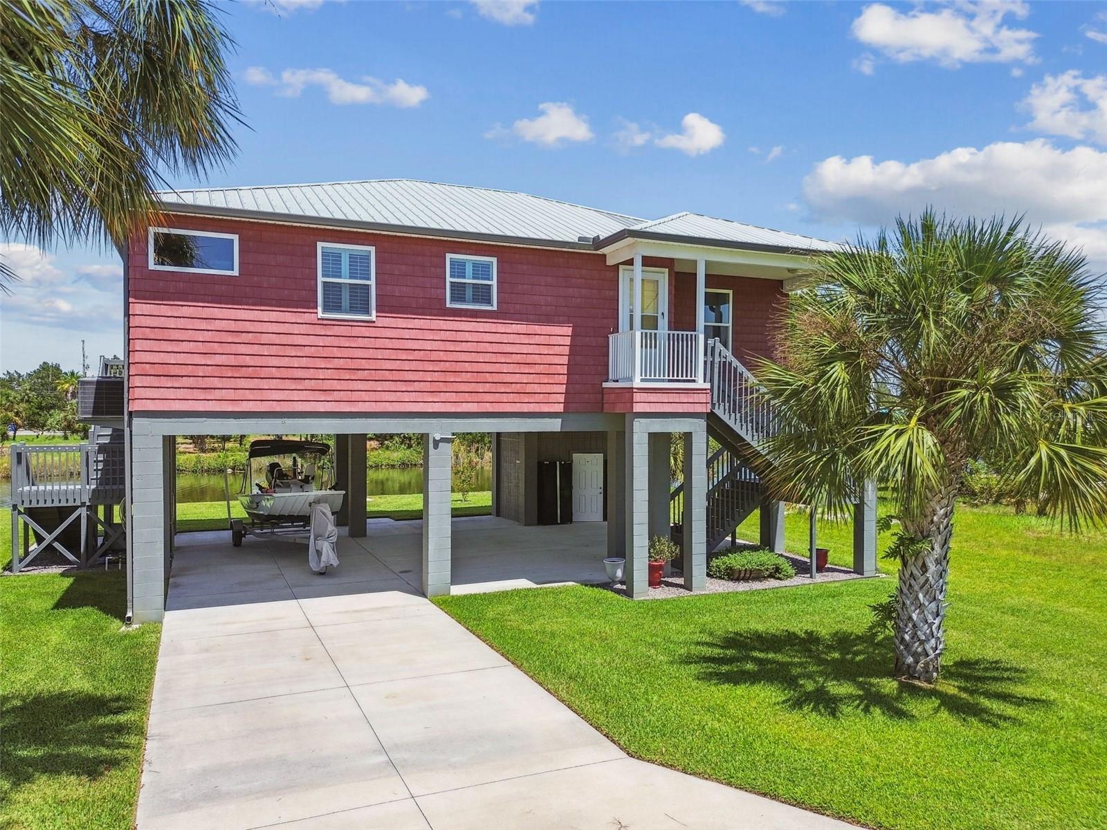 Coastal Living at Its Finest in Hernando Beach! Welcome to this elevated, nearly-new 3 bedroom, 2 bath canal front home located on a peaceful cul-de-sac in beautiful Hernando Beach. Thoughtfully designed and meticulously maintained, this home blends modern comfort with serene waterfront living. Step inside to a bright, open concept layout featuring luxury vinyl plank flooring throughout, a spacious great room, and a stylish kitchen with a large island, soft close KraftMaid cabinetry, and plantation shutters on every window. The adjacent dining area and living room are perfect for entertaining, with water views that steal the show. The split floor plan offers privacy, with two guest bedrooms and a full bath on one side and a generous primary suite on the other, complete with a walk-in closet, direct patio access, and a spa inspired en suite bathroom. Enjoy outdoor living on the shaded, screened rear porch overlooking the canal. The backyard boasts lush irrigated St. Augustine grass, fruit trees, and a newly built seawall and floating dock, ideal for launching your kayak or heading straight to the Gulf via nearby access. The lift is located just a stones throw from the dock! Additional features include impact windows, a stackable washer/dryer, generator hookup, covered stairs, a downstairs storage shed, and an available neighboring lot for expanded possibilities.
