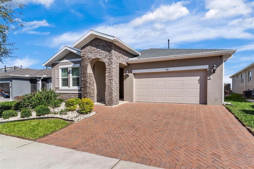 Relaxing Lake Lot Home! This well-maintained 2-bedroom, 2.5-bath home with a den/flex space sits on a peaceful lake lot with no rear neighbors in the guard-gated Trilogy of Groveland community. An extended driveway and added paver areas welcome you HOME! When you walk inside, you’ll find ceramic plank flooring, an 8-foot glass front door, and an open layout filled with natural light. The sunning kitchen offers an massive quartz island, perfect for entertaining! This chef's dream also features a gas range, designer backsplash, crown-molded cabinetry with decorative hardware, a large pantry with pull-outs, and plenty of counter workspace. The living and dining areas flow easily from the kitchen and open directly to the porch and patio areas...taking in that beautiful view. The Master suite overlooks the lake and features a tray ceiling, a spacious bathroom with dual sinks, a separate water closet, linen storage, and a custom walk-in closet with plenty of storage and shelving. The guest bedroom includes its own private en-suite bath and is large enough to accommodate a king-size bed. The den and additional flex/utility space makes the perfect addition for your needs. Triple sliding doors open to a screened lanai with a seamless screen design that keeps the lake views unobstructed. The extended paver patio is ideal perfect for relaxing or enjoying the Florida sunshine. There's even fencing so the pets can enjoy it with you. Trilogy residents enjoy access to a 57,000-square-foot clubhouse with a restaurant and bar, indoor and outdoor pools, fitness centers, walking trails, pickleball, tennis, bocce ball, dog park, and a full schedule of social activities. HOA services include lawn and shrub care, cable, internet, and a guard-gated entrance. Don't miss this amazing home.