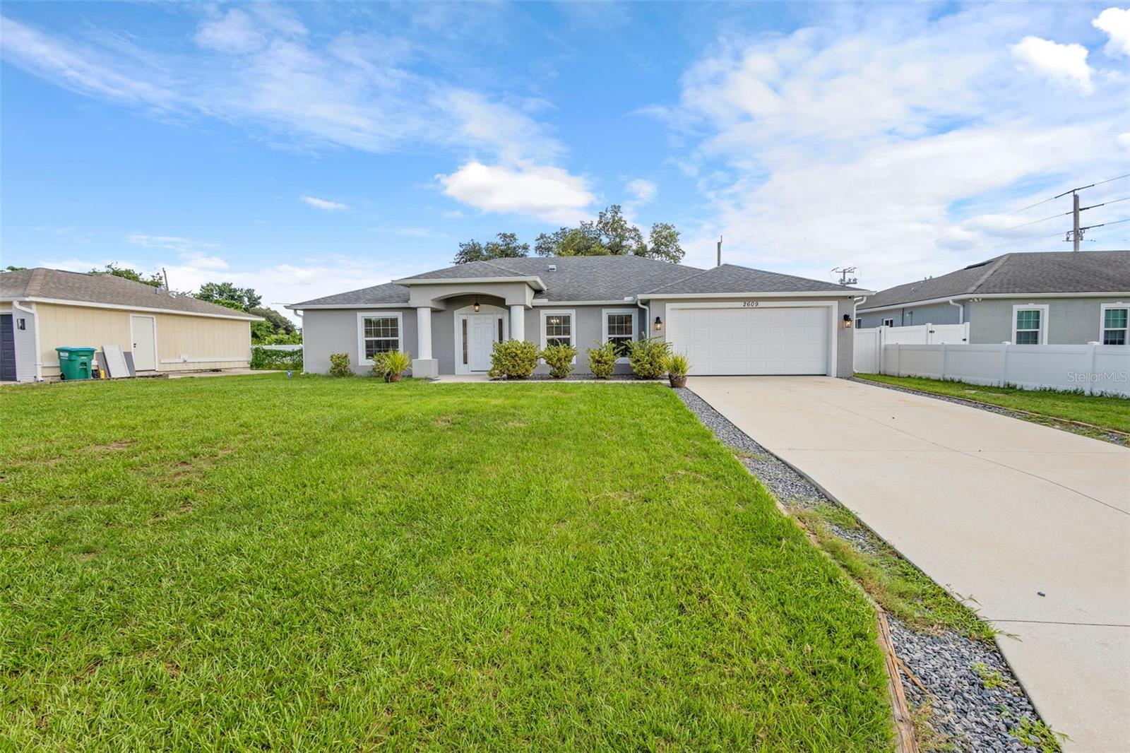 This well-maintained 4-bedroom, 3-bathroom home, built in 2019, offers the perfect blend of modern upgrades, energy efficiency, and comfortable living—all tucked into a quiet Deltona neighborhood close to schools, shopping, dining, and easy I-4 access for commuters.
Step inside to an inviting open floorplan featuring luxury vinyl plank flooring, fresh interior paint, and brand-new carpet in the bedrooms. The layout includes a formal dining room, dedicated home office, and a spacious kitchen/family room combo that brings everyone together. The chef’s kitchen is a dream with a large eat-in island, coffee bar, walk-in pantry, abundant cabinetry, and updated fixtures throughout.
The custom homemade mantle and shelving provide a cozy, fireplace-style focal point in the living area.Retreat to the large primary suite with a huge walk-in closet, garden tub, and plenty of natural light from double-pane windows.
Love the outdoors? This home is built for it. Enjoy a large screened-in patio, vinyl-fenced backyard, and room to add a pool—perfect for entertaining. The long driveway, hurricane shutters, in-wall pest control system, and solar panels (monthly payment just $156.31) add even more value, convenience, and peace of mind.