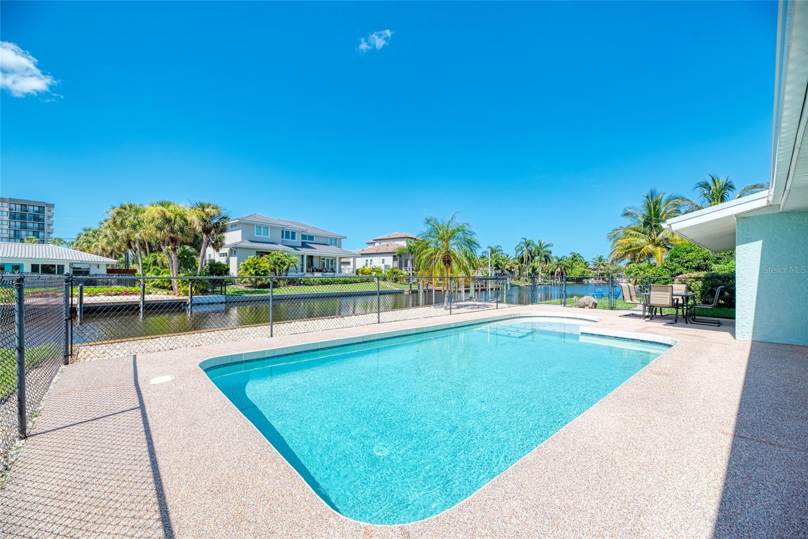 Check out this COMPLETELY REMODELED canal-front pool home on Siesta Key! Picture this: you roll out of bed and grab your coffee, take two steps out of the sliding glass doors, and enjoy it by the saltwater pool. After your coffee, take your morning swim. Then take another 10 steps, or so, and catch some significant fish in the canal which happens to be in your backyard. Chances are that an occasional manatee may swim by for a visit. Fall back into your open-concept home and enjoy a delicious dinner and a great view from your well-equipped kitchen. Oh yes, the pool is open 24-7!