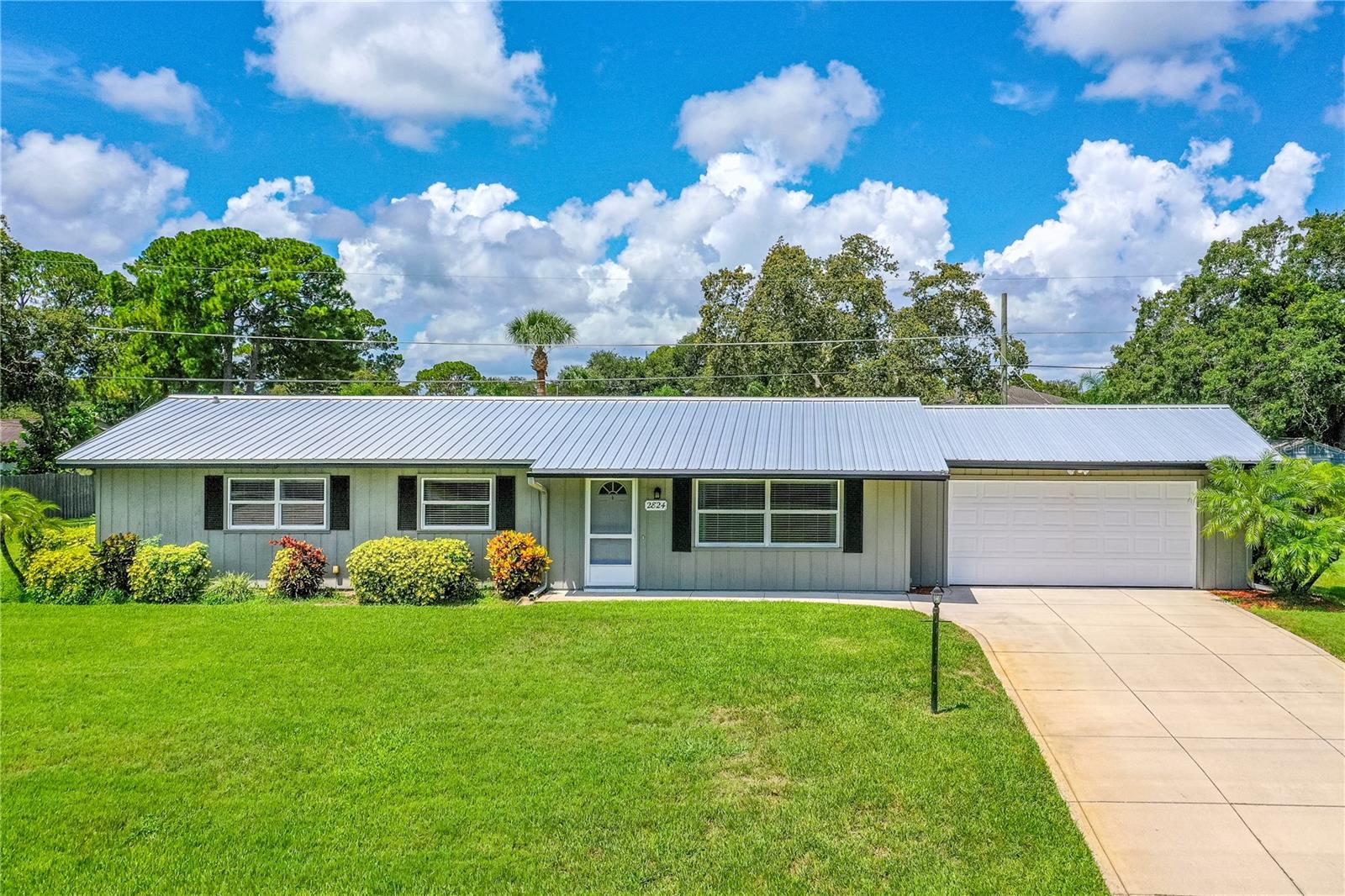 Spacious, Secure, and Ready for Fun! This VERY well-maintained 3 bedroom, 2.5 bath pool home sits high and dry on an oversized 160' x 125' lot in the desirable Florida Shores neighborhood — never flooded and for an additional peace of mind has hurricane impact windows and a durable metal roof. Enjoy outdoor living at its finest with a sparkling pool with sun deck and a dedicated pool bath, just off a large screened-in porch perfect for relaxing or entertaining. NO HOA with extra-large spacious fenced yard offers plenty of room to store your boat, RV, or recreational toys, and includes two large utility sheds for extra storage or workspace. Inside, you’ll find a bright and functional layout with a spacious living area to include a separate living room and family room. Primary suite with full bath and guest bath also conveniently adjoined to one of the bedrooms. Spacious 2-car garage and washer, dryer and garage refrigerator is included with the sale. This home is move-in ready and furniture can be negotiated. This home offers a blend of comfort and style in a fantastic location that is just minutes from the beach and is connected to the regional rails to trails statewide paved trail system. Also close to the Indian River with great waterfront parks and boat launching facilities. Southeast Volusia area is also known for good shopping and great restaurants.