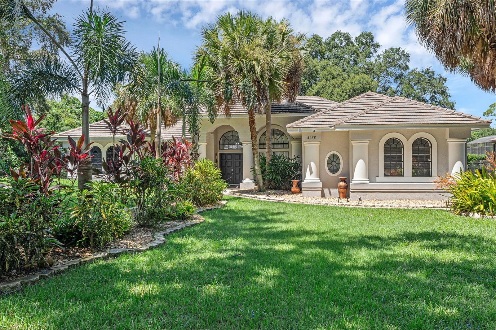 Welcome to this fully renovated 4 bedroom, 3 bathroom pool home, situated on a sprawling 0.73 acre lot. This is truly a home-seekers paradise, with no HOA, an extended driveway leading up to the home on nearly an acre lot. Step through the double entry doors and be greeted by the open floorplan, in which the dining room seamlessly flows into the living room. Tray ceilings can be found in the living room, adding a luxurious touch and french doors lead out to the back patio. Wainscoting walls and an elegant chandelier add the finishing touches to the dining room. As you step into the family room area, you will notice ample natural lighting throughout and a beautiful fireplace. Off of the living room, step into the breakfast nook and state-of-the art kitchen featuring stainless steel appliances, granite countertops with slab backsplash and a kitchen island. The split floorplan creates a private retreat with the primary suite being separate from the other bedrooms and bathrooms. The primary suite features private french doors that lead out to the back patio and an attached en-suite bathroom with walk-in closets, dual sinks, a private watering closet, and a beautiful walk-in shower. In addition, you will find 3 bedrooms and 2 full bathrooms on the other side of the home. The attached in-law suite is perfect for guests, multi-generational living, or whatever fits your family's needs. Within the in-law suite studio, is a living room space, private bedroom, full bathroom with a walk-in shower, and a kitchenette equipped with a stainless steel refrigerator, stovetop, and exhaust fan. Step outside onto your private, outdoor oasis and begin enjoying Florida living. The patio showcases an extended outdoor lanai with ceiling fans, an outdoor pool and spa, stunning travertine pavers, and a screen enclosure around the pool. Outside of the screen enclosure, enjoy an additional paved patio space, perfect for entertainment. This is a rare find so schedule a private showing today and make this house your forever home!