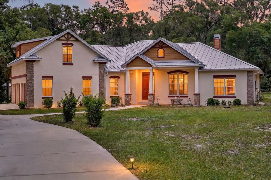 Welcome to 1806 Glenwood Oaks Lane, a private custom-built retreat tucked away on 2.5 acres in the desirable Glenwood Oaks community, perfectly situated on a quiet cul-de-sac. Built in 2017, this modern ranch offers over 3,300 sq ft of thoughtfully designed living space, combining luxury, durability, and functionality. Step inside to find an open-concept layout highlighted by soaring vaulted ceilings with crown molding, wood-look tile flooring throughout the main living areas, and abundant natural light. The gourmet kitchen truly serves as the heart of the home, featuring custom wood cabinetry, granite countertops, pull-out drawers, a natural gas range, tile backsplash, under-cabinet lighting, and a spacious walk-in pantry. The kitchen overlooks the inviting family room, complete with a gas fireplace and stunning floor-to-ceiling stone surround, perfect for entertaining. The split floor plan offers 4 bedrooms, including a private primary suite tucked away for ultimate relaxation, along with generously sized secondary bedrooms featuring ample closet space. Upstairs, you’ll find a one-of-a-kind game room built for entertaining, showcasing Cumaru (Brazilian Teak) hardwood flooring, an Epson projector with surround sound, and reinforced construction with 16,000 lb trusses, ideal for hosting unforgettable game nights. Enjoy seamless indoor-outdoor living with triple sliding glass doors leading to a screened Florida room, perfect for BBQs, relaxing evenings, or enjoying the hot tub while overlooking your expansive, wooded backyard. This home was built with unmatched quality and safety in mind, constructed with solid poured concrete (3000 PSI with fiber mesh), rebar-reinforced block walls, storm-rated windows, and a full-core fiberglass door, effectively making it a true safe room. Additional upgrades include a 50-year metal roof, PGT vinyl low-E windows, a natural gas tankless water heater, and a whole-home water softener/purification system. For those needing extra space, the property also features an over-engineered RV shed rated for 150 mph winds, built on deep concrete piers, complete with dual 50-amp hookups. A detached shed adds even more storage or workspace flexibility, while the expansive acreage provides endless opportunities for outdoor living, recreation, or future additions. If you’re looking for privacy, quality construction, and a property built to stand the test of time, this is it. Schedule your private showing today!