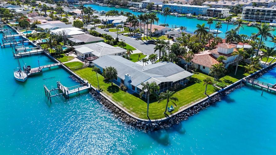 On Isle of Capri, there are only 15 lots with more than 200 linear feet of open waterfront! Since 2018, only 3 of these lots have been sold via an arm’s length transaction. More often than not, lots such as these, stay within the family. Today, for the first time - in a long time – one of these prized-possession lots hits the market with 237’ of waterfront on .3224 acres. This fabulous lot is 100’ deep with  100’ + 137’ of waterfront, with ample room for you to add a fabulous pool! The 100’ is on open water and the 137’ is on a canal, providing a protected place for your boat(s). The dock, which was renewed in 2014, has a 16,000 lb. lift. The formidable seawall had a new cap and anchors, as well as 64 cubic yards of rip rap installed in 2014. Everything about this property centers on the waterfront. The views are breath-taking and the boating lifestyle enviable. And yet, this home has so much more to offer, including proximity to the beach and warm Gulf waters! There is a plethora of things to enjoy on the mainland of Treasure Island, in addition to the fabulous beach, which, by the way, is within easy walking distance! Treasure Island has wonderful restaurants and fun night spots galore! And after you have finished a ‘hard day’ on the water or having fun at the beach and/or beach bars, you can come home to this incredible 3 bedroom, 3.5 bath quintessentially authentic Florida home. You will fall in love with the beautifully done open-plan kitchen and matching main guest bath, both of which enjoyed a tasteful remodel in 2020. With 2,582 acsf of fine Florida living PLUS the large (65’ X 14’) screened patio that faces Johns Pass, there is space galore for living life, entertaining friends and enjoying the great Florida outdoors!  Then there is the awesome garage with both front and back garage doors for easy transportation for all your water toys! AND…. the garage has the HUGE ADDED BONUS of an additional adjacent 30’ X 16’ multi-purpose room that could be your studio, gym, luxurious she-shed, man-cave OR whatever tickles your fancy! All-in-all, the home enjoys 4,842 total sq ft!  All windows are either impact or have newer (2021) accordion storm shutters, making storm prep a breeze! (Pardon the pun! ;o) Carpe diem! Tomorrow may be too late!