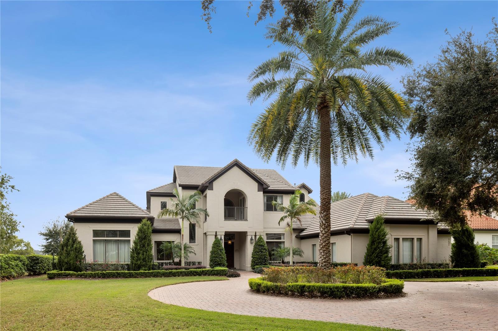 Welcome to your serene custom estate, offering unobstructed water views at every turn, situated on the shores of Lake Olivia within the gated community of Weatherstone. Just minutes from downtown Windermere and Orlando's premier attractions, this property combines luxury and convenience. As you approach, a circular paver driveway and stunning Florida landscaping set the stage for elegance. Recent enhancements, including fresh paint inside and out and new landscaping in both the front and back, elevate the home's appeal. The open formal space invites you in with sweeping lake views through a wall of glass doors. A unique expansive wing features a spacious primary bedroom with panoramic water vistas, a private library/office, a gym/studio, a morning bar, and a meditation patio, along with an impressive dressing area complete with custom built-ins.The spa-like bathroom has been newly remodeled to include an extra-large shower with multiple body sprays and a rain shower, alongside dual custom vanities, and ample storage. The exquisite chef’s kitchen boasts a Viking gas range, double ovens, a warming drawer, an oversized island, and a custom walk-in pantry, seamlessly flowing into a generous breakfast nook and family room. Adjacent to the kitchen, a custom butler's pantry features two wine refrigerators and cabinetry. Recent upgrades include a new refrigerator, dishwasher, and microwave, as well as two new garbage disposals. For entertaining, the first-floor movie theater with Dolby Atmos surround sound featuring 13 speakers and a 4K projector with a 130” screen. While the waterfront billiards room, complete with a full bath and bar are great for family game nights. Additionally, another ensuite bedroom on the first floor offers a full bath and large closet. The home's new outdoor kitchen, new gas fire pit, and outdoor sound system enhance your outdoor entertaining experience. Upstairs, you will find three more ensuite bedrooms, each with private baths and balconies overlooking the picturesque water or landscaped grounds. The home is replete with abundant storage and numerous designer upgrades, including coffered ceilings, crown molding, and custom window coverings throughout. The breathtaking lanai area features a full summer kitchen, an infinity-edge pool, and extensive covered entertaining spaces, perfect for year-round enjoyment. The pool and spa have been refinished with a new surface and coping, complemented by a new saltwater system with automatic app control. The expansive backyard, adorned with mature landscaping and 100 feet of private frontage on Lake Olivia, creates an ideal setting for boating, fishing, paddle boarding, and more, with a new Trex dock equipped with a boat lift and two jet ski lifts. Additional features include a dog run with artificial turf for easy cleanup, three new tankless water heaters, new washer and dryer, closet organizers throughout the house. The garage boasts a new epoxy floor and two new garage door openers. A mosquito misting system covers the entire house and backyard, ensuring your outdoor space remains enjoyable year-round.