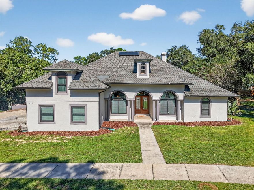 Welcome to 1257 W Lake Brantley Road, where elegance meets everyday comfort in one of Longwood’s most desirable neighborhoods. Nestled on more two acres, this custom-built 5-bedroom, 4-bath home offers both space and sophistication, along with a large detached workshop/garage that is perfect for car enthusiasts, hobbyists, or anyone needing extra storage.

Step inside to soaring ceilings, arched windows, and a bright, open layout that feels instantly inviting. The spacious living room features a cozy fireplace and beautiful double front doors that fill the space with natural light. The chef’s kitchen includes granite countertops, rich wood cabinetry, stainless steel appliances, and a bar-top counter ideal for casual dining or entertaining. Roof replaced January 2021.

The primary suite is a true retreat, complete with tray ceilings, warm wood look flooring, and a luxurious ensuite bath. Additional bedrooms are generously sized, and the upstairs bedroom offers flexibility for a game room, gym, or home office.

Out back, enjoy terraced landscaping, a covered patio and yard shaded by mature trees. The oversized detached building with roll-up doors and power provides ample room for a workshop, RV, or small business setup.

Located in the highly sought-after Lake Brantley school district and just minutes from shopping, dining, and Wekiva Springs, this home combines convenience, craftsmanship, and character.