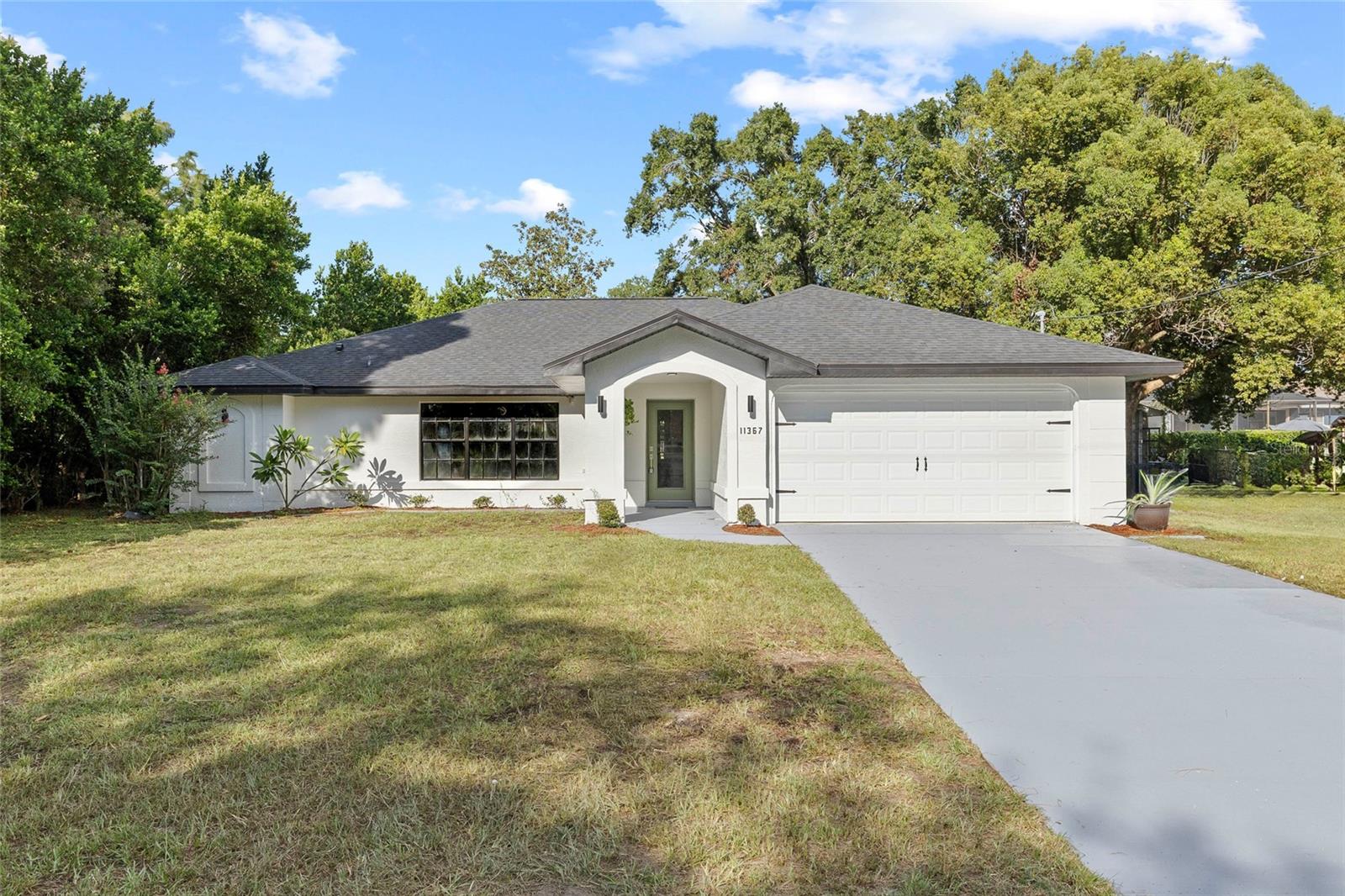 Welcome to this stunningly renovated POOL home in Spring Hill! This beautifully updated 3-bedroom, 2-bathroom residence combines modern design, spacious living, and your very own screened-in pool retreat. From the moment you arrive, you’ll love the charming curb appeal and inviting entry. Step inside to soaring vaulted ceilings and a bright open floor plan that creates a light, airy atmosphere throughout. The living and dining areas flow seamlessly into a gorgeous, modern kitchen featuring a large peninsula with bar seating, sleek quartz countertops, brand-new cabinetry, stainless steel appliances, and plenty of storage—perfect for both entertaining and everyday living. The split floor plan provides comfort and privacy, with the spacious primary suite tucked away on one side. Filled with natural light, it boasts a walk-in closet and a spa-inspired ensuite bathroom with a stand-alone soaking tub you’ll never want to leave. On the opposite side, two additional bedrooms share a stylishly updated full bathroom, while a dedicated laundry room connects to the 2-car garage for added convenience. Glass sliders lead you from the main living area to the covered patio and fully screened-in pool, creating the ultimate indoor-outdoor living experience. Whether you’re enjoying quiet evenings at home or hosting family and friends, this backyard oasis is ready year-round. Additional updates include a brand-NEW ROOF, giving you peace of mind for years to come. Perfectly located just 11 minutes from Weeki Wachee Springs and Preserve, 20 minutes from Sweetfields Farm, and under 15 minutes from Adventure Coast Fun Park, this home places you near nature, entertainment, and everyday conveniences. Don’t miss your chance to own this move-in-ready gem—schedule your private showing today and make this Spring Hill pool home yours!