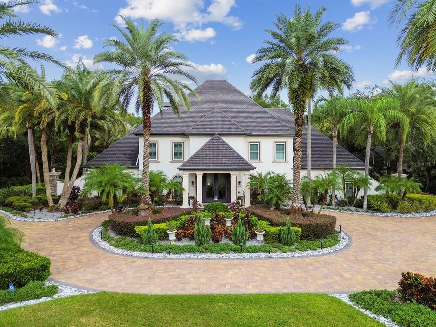 Situated in The Reserve at Tampa Palms, one of Tampa’s most prestigious gated golf course communities, this estate offers an extraordinary Florida luxury lifestyle. The community’s private club provides access to a fitness center, swimming pools, tennis courts, banquet facilities, and a fine-dining restaurant, creating the perfect blend of active living and social amenities. Fully updated in 2024, this luxurious home spans ¾ of an acre and presents a seamless combination of modern comfort and resort-style amenities.
This property’s outdoor oasis, honored with the Pinnacle Luxury Pool Award and The World’s Greatest Pool Award, was also featured on HGTV for its breathtaking design. The outdoor sanctuary includes a resort-style pool and spa, fountains, multiple fire pits, a striking fire sculpture, and a cozy fireplace. Entertain effortlessly with a fully equipped outdoor kitchen and bar, surrounded by 4 smartly placed TVs for game days or movie nights. The expansive backyard offers abundant space.
The huge circular driveway enhances the home’s curb appeal as you arrive under portico as guests are welcomed through an 18-foot custom front door. The grand entrance, with its 30-foot ceilings and curved staircase, offers a striking first impression. Inside, the home features elegant, open-concept spaces that make every moment feel special. The first-floor primary suite boasts a newly designed en-suite spa bath with a garden tub, multiple shower heads, water jets, and double vanities and a custom closet that will rival any other.
The heart of the home lies in the newly remodeled gourmet kitchen, featuring waterfall quartz countertops, top-of-the-line appliances, beverage drawers, a double oven, a pot-filler over the induction cooktop, and a dedicated drink and coffee bar. Whether hosting formal dinners in the stunning dining room, which includes a custom wine wall and built-ins, or enjoying casual evenings in the open living room with its coffered ceiling and fireplace, this home offers spaces designed for every mood and occasion.
Additional features include an executive office with custom cabinetry and display shelves, as well as a versatile third-floor bonus area. The entire top floor serves as an adult retreat, complete with a fitness area, media section, poker table, full bar, pool table, and half bath. Upstairs, there are 4 oversized bedrooms all with brand new en-suite baths.  The property has ample extra parking and 3 car garage, complete with a car lift—a dream setup for any car enthusiast.
With no detail left untouched, a resort style outdoor sanctuary, and multiple living areas, this estate embodies both luxury and practicality. The large backyard offers a perfect escape, while the seamless flow between indoor and outdoor spaces makes it ideal for entertaining.
