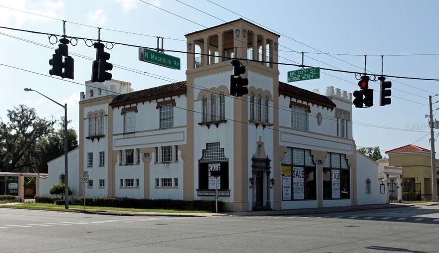 939 N Magnolia Ave in Ocala is a rare opportunity to acquire a fully reimagined historic landmark—formerly a Coca-Cola Bottling Plant—originally constructed in 1939 totaling 9464 SF and designed in the Mission/Spanish Revival style of architecture and completely remodeled into a modern gallery and professional office environment while preserving the architectural character and aesthetics of the period with a contemporary design twist. The property is situated on approximately 0.63 acres and is zoned B-5, allowing for a wide variety of commercial uses, and benefits from dual ingress and egress to both North Magnolia Avenue and Bonnie Heath Boulevard. The building features a flexible, high-quality interior layout ideal for creative, professional, medical, or showroom users, and the second-floor space is fully serviced by an elevator, providing convenient access for staff and visitors. This one-of-a-kind offering combines historic charm, modern functionality, prominent corridor visibility, and exceptional site access in a premier central Ocala location.