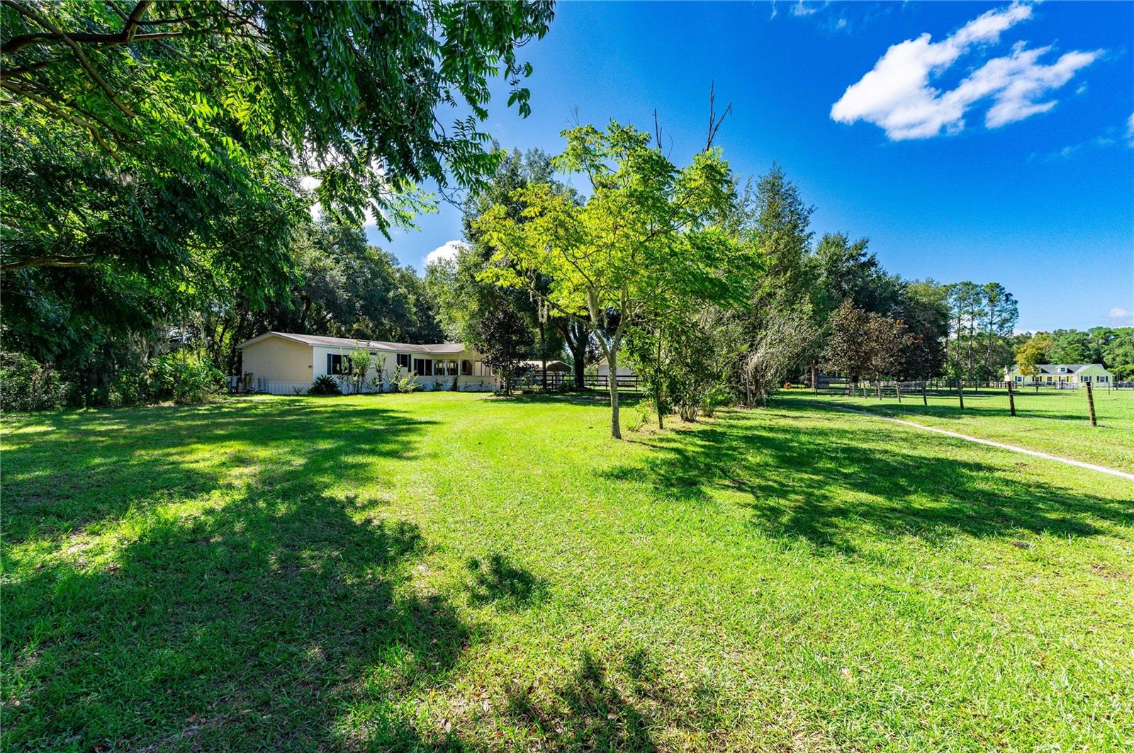 MARKET ADJUSTEMENT: Spacious mobile home is situated on a generous .75-acre lot, offering ample space for outdoor activities and gardening. With four bedrooms and two bathrooms, it provides plenty of room for a growing family or extra space for guests. The walk-in closets in the bedrooms provide convenient storage solutions. One of the standout features of this home is the vast front porch, perfect for enjoying the outdoors, hosting gatherings, or relaxing with a morning coffee. The porch adds both charm and functionality to this property. With almost 1,800 square feet of living space, there's room for everyone to spread out and make this home their own. Whether you're looking for a family residence or a spacious getaway, this mobile home has the potential to fulfill your needs. Multitude of updates: All new skirting and tie downs to be financing compliant, updated electrical, completely re-plumbed house, add water treatment, completely new shingle roof, new water heater, new range. You won't be able to find all these upgrades at this price!