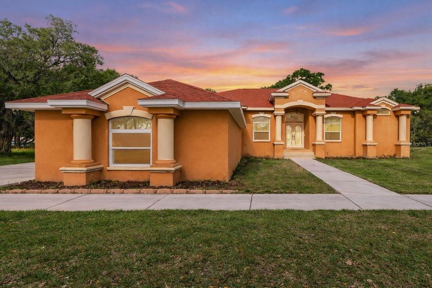 Situated on nearly 2 acres with no HOA or CDD, this 4-bedroom, 3-bath, 3-car garage home offers privacy, space, and flexibility in Wesley Chapel. Built in 2002, the home features a split, open floor plan with high ceilings, arched architectural details, and multiple living and dining areas filled with natural light.

The kitchen overlooks the main living space and includes granite countertops, solid wood cabinetry, a center island, and bar seating, ideal for entertaining. The spacious primary suite and additional bedrooms provide comfortable separation, while a large dedicated office can easily function as a 5th bedroom or flex space.

Enjoy outdoor living with a screened-in lanai that opens to an oversized paver patio and expansive backyard surrounded by mature trees. The property offers plenty of room for boats, RVs, or future additions.

Major updates include a 1-year-old roof, newer hurricane-impact windows, 5-year-old HVAC, and a 1.5-year-old well system. The home is on well and septic, keeping utility costs low.

Seller has obtained a professional exterior repaint quote for buyer convenience. A credit toward repaint may be offered with acceptable terms, allowing the buyer to customize to their preference.

A rare combination of land, upgrades, and location, close to Wesley Chapel amenities while still offering a private, estate-style setting.