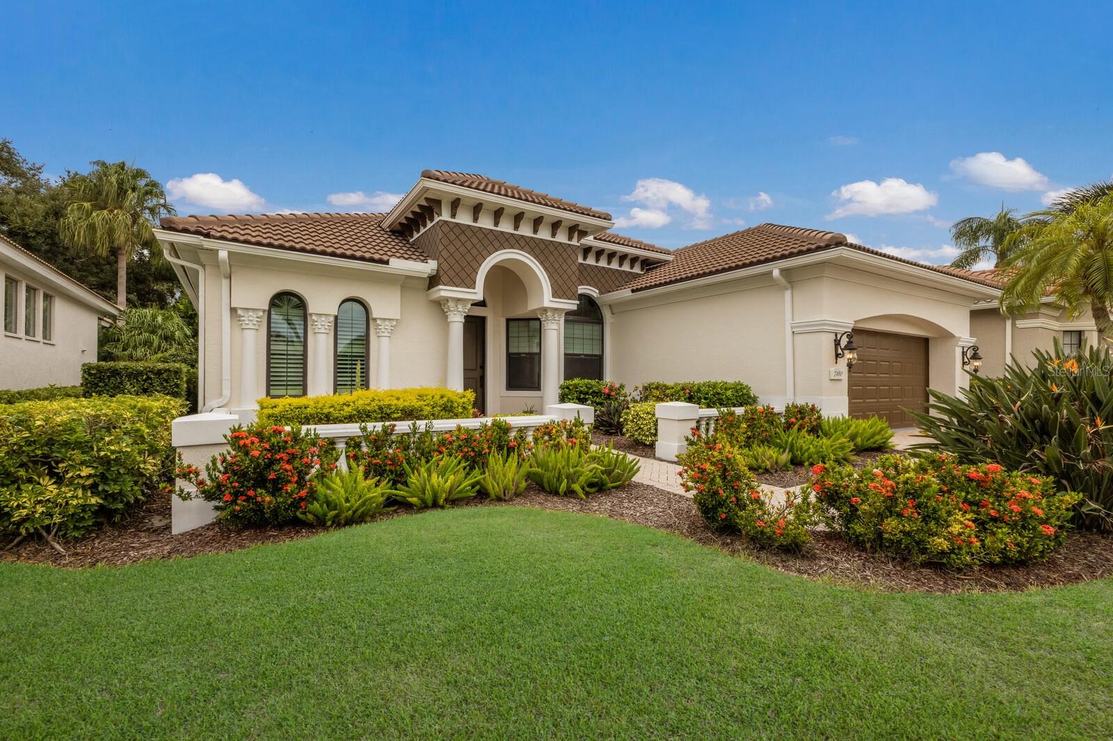 Experience refined Florida living in this beautifully maintained 2-bedroom, 2-bath home with a flexible den/office that can easily serve as a 3rd bedroom with included murphy bed. Improvements consist of all-impact windows/sliders, garage doors plus a new roof. Designed with comfort and style in mind, this residence features soaring ceilings, engineered hardwood flooring, plantation shutters, and detailed molding. The oversized primary suite offers lanai access, a spacious walk-in closet, dual sinks, walk-in shower, and private water room. Guests will enjoy a generously sized bedroom with lanai access, while the second bath is conveniently positioned for both guest and living room use. Upon entry, impact sliding doors flood the open living and dining areas with natural light, showcasing lush landscaping. The privacy of the lot and tropical landscaping creates a serene, inviting retreat. Step outside to your private oasis, complete with an outdoor kitchen featuring a built-in grill and mini fridge—perfect for year-round entertaining. Additional highlights include a large laundry room with cabinetry and an oversized 2-car garage with abundant storage. This home is in a maintenance free neighborhood step away from the community pool and spa. Located in the gated Lakewood Ranch Country Club, this home offers optional memberships that provide access to four private golf courses, three restaurants, pickleball, tennis courts, and athletic center. The country club is centrally situated near fine dining and shopping at Waterside Place and UTC. Convenient access to both Sarasota and Tampa airports, and just a short drive from some of the nation's most beautiful beaches make this a perfect location.