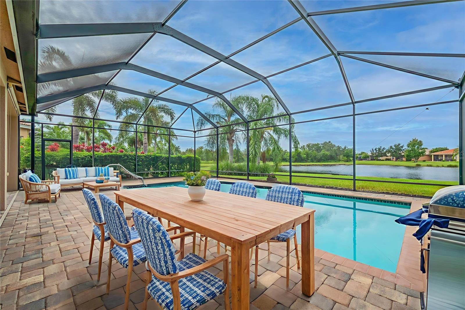 One or more photo(s) has been virtually staged. Welcome to this amazing Florence model from GL Homes’ exclusive Crown Collection, perfectly situated on a private cul-de-sac street in the heart of Valencia Lakes, Tampa Bay’s premier 55+ resort-style community. Nestled on a one-of-a-kind homesite that backs onto a breathtaking panoramic water view, this home offers the ultimate Florida lifestyle with stunning sunsets enjoyed from your oversized 15x30 foot heated saltwater pool. The pool area features upgraded pavers, a screen enclosure, a covered lanai, and a new pool heater—perfect for relaxing or entertaining in style. From the moment you arrive, the bay window, upgraded landscaping, and custom plant-bed curbing create exceptional curb appeal. Step through the elegant 8-foot glass entry door and into a bright, airy interior with soaring 13-foot ceilings and large tile flooring throughout for easy, low-maintenance living. The open-concept design seamlessly connects the spacious great room, kitchen, informal dining room, and extra-large breakfast bay, all flowing naturally to the private lanai and pool area overlooking the tranquil water. The gourmet kitchen is a chef’s dream, featuring granite countertops, a full granite backsplash, undermount stainless steel sink, 42" soft-close raised panel maple cabinets, stainless steel appliances including a brand-new dishwasher, new space-saver microwave, French door refrigerator, slide-in range, cabinet pantry, cabinet panel package, roll-out shelving, and a convenient built-in menu desk. Retreat to the luxurious primary suite with a coffered ceiling, triple sliders opening to the lanai, and two large walk-in custom built-in closets. The spa-like primary bathroom offers a Roman tub, walk-in shower with full wall tile and built-in seat, dual granite vanities with undermount sinks, and upgraded raised panel maple cabinetry. The second bedroom includes a beautiful bay window, custom built-in desk workspace, and tile flooring, while the third bedroom offers double 6-panel solid doors, a closet, and tile flooring, making it ideal for guests or a home office. The second full bathroom is equally impressive with a tub/shower combination, granite countertops with extended banjo top, and stylish maple cabinets. Additional features include a separate laundry room with white cabinetry, front-load GE washer and dryer, and a utility sink. The home is loaded with upgrades such as a new water heater, designer lighting and ceiling fans, custom interior paint throughout (including ceilings), epoxy-coated garage floor, overhead garage storage racks, garage storage cabinets, accordion hurricane shutters, rain gutters, water softener system, custom built-in closet organizers, extra recessed lighting, and a whole-house surge protector. Living in Valencia Lakes means access to a 40,000 square foot clubhouse, resort-style pools, restaurant, fitness center, tennis, pickleball, walking trails, live shows, arts and crafts, and a wide array of clubs and activities. This immaculately maintained home is truly move-in ready and represents one of the most desirable offerings in this sought-after community. Don’t miss the opportunity to make this exceptional home your own.