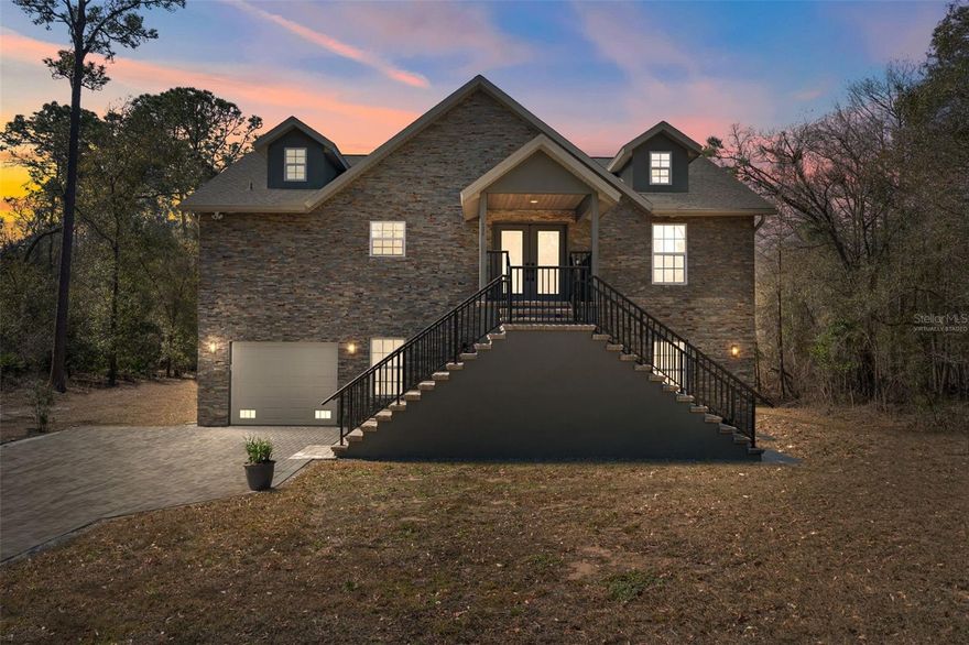 One or more photo(s) has been virtually staged. This stunning custom-built home offers direct waterfront living on a serene canal that leads straight to the Withlacoochee River — perfect for boating, fishing, kayaking, and enjoying Florida's natural beauty right from your backyard.
Meticulously designed with premium finishes and thoughtful details throughout, this open and bright residence boasts vaulted ceilings with beautiful Synergy tongue-and-groove pine that create a warm, spacious feel. The primary living areas feature elegant crown moulding, beam ceilings, recessed lighting, accent lighting, wall sconces, and a cozy electric fireplace with heater. Natural light floods the home through large windows, 9' French doors opening to the balcony patio, and beautiful double glass front doors.
The gourmet kitchen is equipped with brand-new matching GE stainless steel appliances, including a WiFi-connected flat-top GE Smart range and air-fry oven, quartz countertops, stone backsplash, shaker soft-close cabinets, and counter-height cabinets in the bathrooms. Floor-to-ceiling tile and stone accents grace the bathrooms, featuring a dual vanity Jack-and-Jill bathroom between the 2nd and 3rd bedrooms. Luxury vinyl plank (LVP) flooring is installed over extra underlayment for added comfort, complemented by 6" baseboards, solid core shaker-style doors throughout (including bedrooms, bathrooms, and laundry), and custom door and window casings.
Additional highlights include a custom water filtering and water softener system, underground power to the home, gutters, blinds throughout, and a ship-lap wall accent in the primary bedroom.
Step outside to discover exceptional outdoor living: a full brick paver driveway, extensive stone work (interior and exterior), stone walls, and brick accents. The 7.5-car garage features a durable two-part epoxy-coated slab flooring. A pavered 2nd-story deck/lanai with custom paver finish, custom black aluminum railing, and stunning views overlooks the water, while the 400 sq ft dock provides direct access to your private canal and the Withlacoochee River beyond.
Custom touches abound with low-voltage lighting along the driveway and stair entries, custom aluminum handrails throughout, and solid core interior doors.
This one-of-a-kind, move-in-ready residence combines high-end craftsmanship, thoughtful design, and unbeatable waterfront location in a peaceful setting. Don't miss the opportunity to own this truly special custom-built canal-front home!