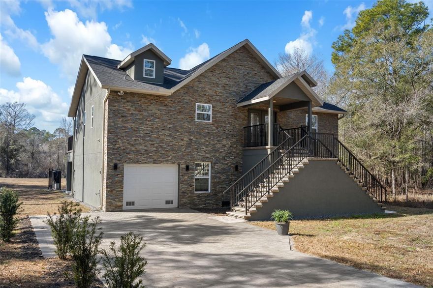 One or more photo(s) has been virtually staged. ENGINEERED AND BUILT FOR WATERFRONT LIVING! This stunning CUSTOM BUILT home offers direct WATERFRONT living on a serene canal that leads straight to the Withlacoochee River. Perfect for boating, fishing, kayaking, and enjoying Florida's natural beauty right from your backyard. Meticulously designed with PREMIUM FINISHES and thoughtful details throughout, this OPEN AND BRIGHT residence boasts SOARING VAULTED CEILINGS with beautiful SYNERGY TONGUE-AND-GROOVE PINE that create a warm, spacious feel. The primary living areas feature elegant crown molding, BEAM CEILINGS, recessed lighting, accent lighting, wall sconces, and a cozy electric fireplace with heater. NATURAL LIGHT floods the home through LARGE WINDOWS, 9' FRENCH DOORS opening to the balcony patio, and beautiful DOUBLE GLASS FRONT DOORS. The GOURMET KITCHEN is equipped with brand-new matching GE stainless steel appliances, including a WiFi-connected flat-top GE Smart range and air-fry oven, QUARTZ countertops, STONE backsplash, SHAKER STYLE SOFT CLOSE CABINETS. Counter-height vanities, FLOOR-TO-CEILING TILE, STONE ACCENTS AND QUARTZ countertops grace the stunning bathrooms. A Dual vanity Jack-and-Jill bathroom is located between the 2nd and 3rd bedrooms. Luxury vinyl plank (LVP) flooring is installed over extra underlayment for added comfort, complemented by 6" baseboards, solid core shaker-style doors throughout (including bedrooms, bathrooms, and laundry), and custom door and window casings. Additional highlights include a custom water filtering and water softener system, underground power to the home, gutters, blinds throughout, and a ship-lap wall accent in the primary bedroom. Step outside to discover exceptional outdoor living: a full brick paver driveway, extensive stone work (interior and exterior), stone walls, and brick accents. The 7.5 CAR GARAGE features a durable two-part epoxy-coated slab flooring. The 2nd-story deck/lanai features a custom paver finish, custom black aluminum railing, and stunning views overlooks the water, while the 400 sq ft dock provides direct access to your private canal and the Withlacoochee River beyond. Custom touches abound with low-voltage lighting along the driveway and stair entries, custom aluminum handrails throughout, and SOLID CORE INTERIOR DOORS. This one-of-a-kind, move-in-ready residence combines high-end craftsmanship, thoughtful design, and unbeatable waterfront location in a peaceful setting. Don't miss the opportunity to own this truly special custom-built canal-front home!