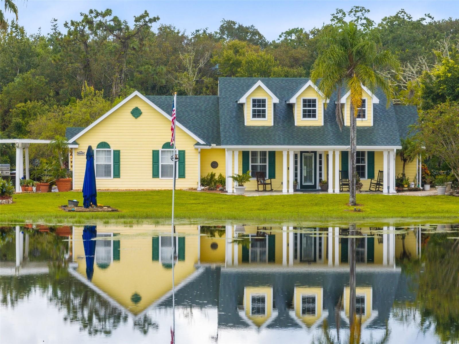 Welcome to your own private piece of Florida- where country living meets convenient location. This custom-built 3 bedroom, 2 bath pool home is perched on a stunning nearly 5 acre homestead with one of the most beautiful spring-fed ponds you've ever seen! Come home from work, park anywhere you like- under the pergola car-port, in one of the pole barns, or along your circular driveway (there's no HOA here!) head out on your paddle-board or grab your fishing reel and start casting. With the fully-stocked over 1 acre pond, you're sure to land a big one! Then, jump in the salt-water pool to refresh after a long, hot day. As you float to the sound of the waterfall, take in views of your lush, green pasture that are equipped for horses or other animals. 2 stalls are complimented by a feed and tack shed, making a great place to raise 4H animals. Also outside, is a koi river that flows through a rock garden surrounded by beautiful plants and flowers. Inside the home you'll find lots of French doors, perfect for entertainment and taking in all the views this property showcases. The family room opens to the pool and patio area complete with outdoor bar and entertainment space. Separate from the family room is an impressive bonus living-area currently used as a game room with dry-bar. The attic above this room can be built-out to add an additional bedroom. Off the living room and foyer is an office/den with built-ins. This home has been well loved and cared for by its original owners, and is ready for a new family to begin their own story here!
