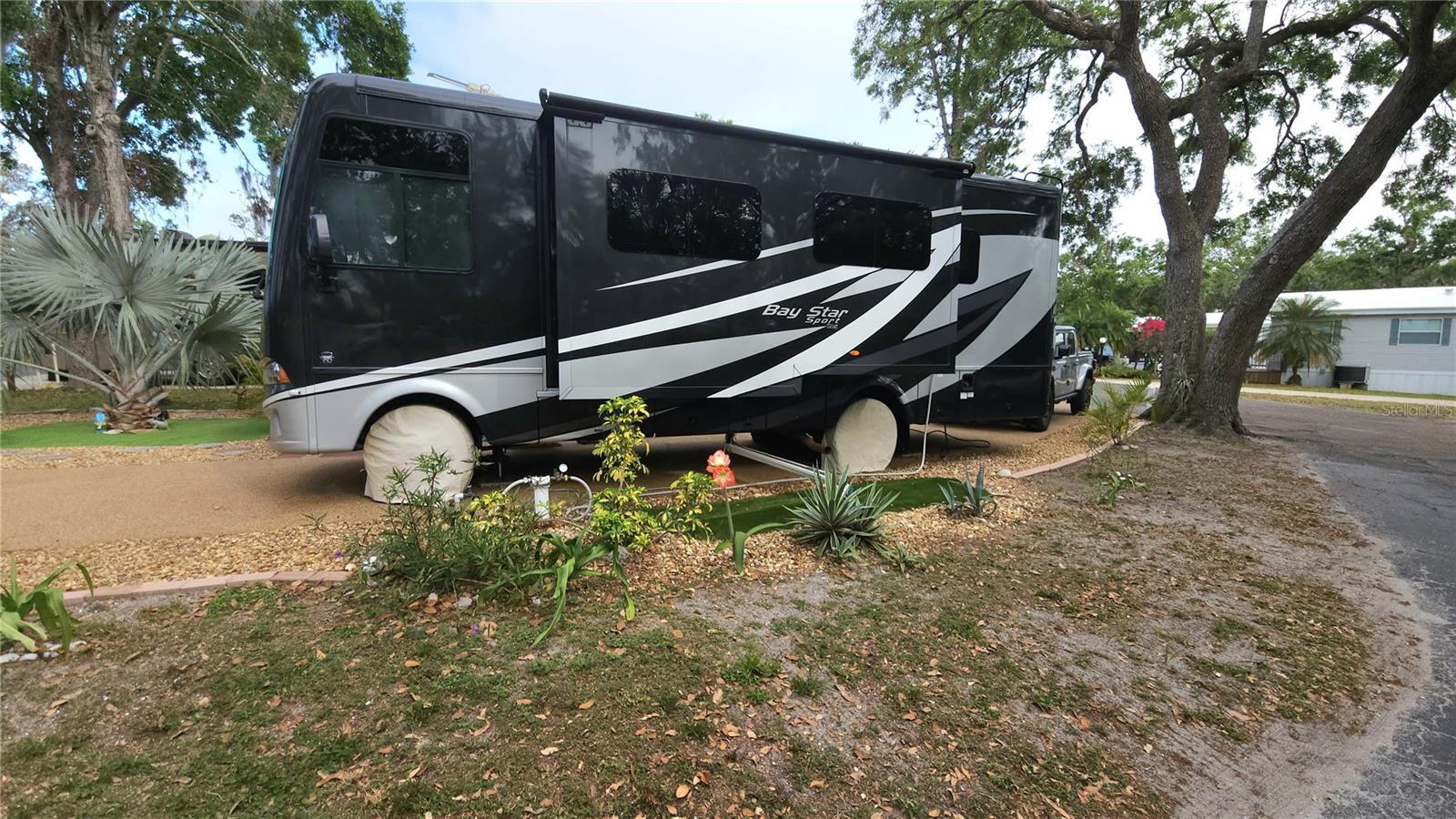 UNIQUE, LANDSCAPED RV LOT IN ACTIVE 55+ COMMUNITY! This pull-through RV lot is located in SUGAR CREEK RESORT. Nestled in the back of the community, this quiet spot is on a curved end lot. Pebble treatment on the pavement and a 10' x 26' patio add to the charm. There is a granite topped buffet table which enhances your outdoor experience. Included with the lot is a grill, furnishings, and a cabinet shed where you can store your gear. HOA fees of $442 each quarter include water, sewer, trash, and grass mowing. Amenities include heated pool, clubhouse, tennis, pickleball, shuffleboard, workshop, laundry and shower facilities. Don't miss out on this slice of Florida paradise.