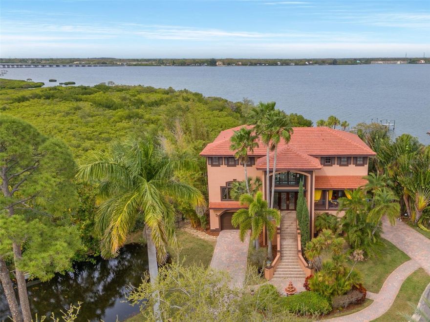 Welcome to this stunning WATERFRONT estate, set on nearly an acre in desirable Philippe Pointe.
Proven Resilience: This home weathered recent storms with minimal impact (no flooding, etc.). Located against the serene backdrop of Safety Harbor, it boasts RARE water access and views leading directly to Tampa Bay, making it a haven for boating enthusiasts and waterfront living lovers. Spanning three levels, this estate features 6 bedrooms, 4.5 bathrooms, a POOL, hot tub, 2 kitchens, a sauna, and nearly 6000 sq. ft. of luxurious living space. With two entry points, it’s perfectly designed for a true in-law suite.
Step into soaring ceilings framed by expansive windows and doors showcasing breathtaking water views from every angle. An elegant staircase with wraparound balconies overlooks the living room below, offering additional water vistas. Tuscan-inspired design flows throughout, with travertine, engineered hardwood flooring, crown molding, bespoke faux paint, and intricate murals adding a distinctive ambiance.
The chef’s kitchen on the main floor boasts wood cabinetry, granite countertops, top appliances, an oversized stainless steel refrigerator, Jenn-Air double ovens, and a wine fridge. A spacious pantry and laundry room—with a chute from the upstairs primary bedroom—add convenience. A dumbwaiter connects the kitchen to the garage for seamless grocery transport.
Also on the main floor, you’ll find a full bedroom and walk-in closet, with dual access to front and back verandas and a Jack & Jill ensuite featuring a walk-in shower. Enjoy the connected balcony with ample seating to entertain while soaking in panoramic water views.
On the upper level, the primary bedroom suite features a spa-like ensuite with a jetted garden tub, walk-in shower, dual vanities, and a custom walk-in closet. Flooded with natural light, the suite opens onto a private balcony overlooking the water—perfect for morning coffee with sunrise views. This level also includes two additional bedrooms and a full bathroom. One has been transformed into a stunning library-style office with wood built-ins.
The lower level offers a fully equipped kitchen (wood cabinetry, granite counters, dishwasher, range, refrigerator, wine fridge), two spacious bedrooms, a living room/flex space, and a laundry room. The two-car garage has been converted into a yoga studio/gym, with three French doors opening poolside.
Outside, indulge in resort-style living with an outdoor Jenn-Air kitchen, an oversized swimming pool, a custom-built sauna, a hot tub, and lush landscaping for privacy. A brand-new dock with boat lift access and a private beach just steps away. 
Additional highlights: NEW roof (2023) NEW AC units (2023, 2024) Storm windows & shutters, Cul-de-sac location, less than a mile from Philippe Park,Minutes from Safety Harbor’s vibrant downtown, with boutiques, restaurants, galleries, and Florida’s iconic beaches nearby
Call now to schedule your private showing!
