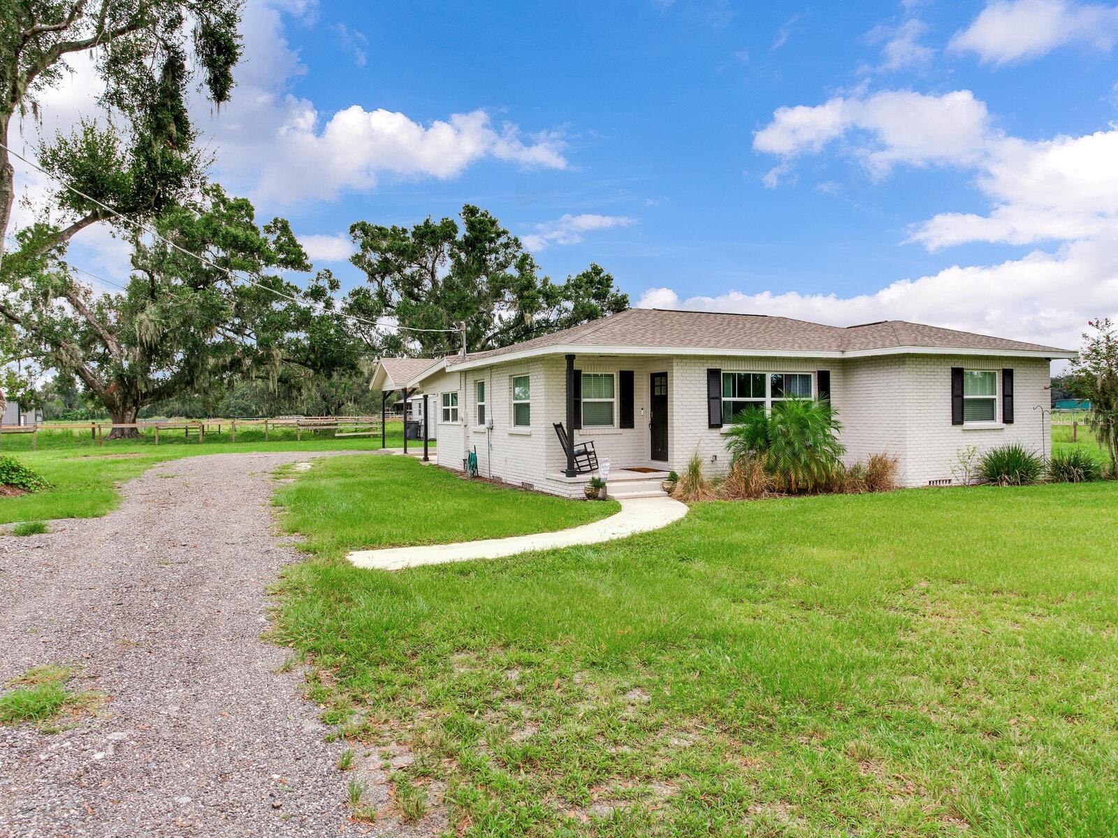 COZY COTTAGE NESTLED AMONG SPRAWLING OAKS AND LUSH PASTURE! Welcome to this beautifully remodeled 3BR/1BA home where cozy character meets stylish upgrades on a spectacular 12+/- acres. The kitchen steals the show with granite countertops, bold cabinetry, farmhouse sink, dining nook, and updated appliances. Natural light floods the spacious living room, highlighted by an accent wall and comfortable seating area that make it the heart of the home. Every detail has been refreshed, from new flooring and paint to updated trim, windows, and doors. Practical spaces shine too, with a closed-in back porch, functional laundry room, and carport with covered walkway. Beyond the home, this property’s ranching roots shine through with two ponds, a large equipment barn, an agricultural well, and thriving pasture—ready for cattle, horses, or simply enjoying the open countryside.