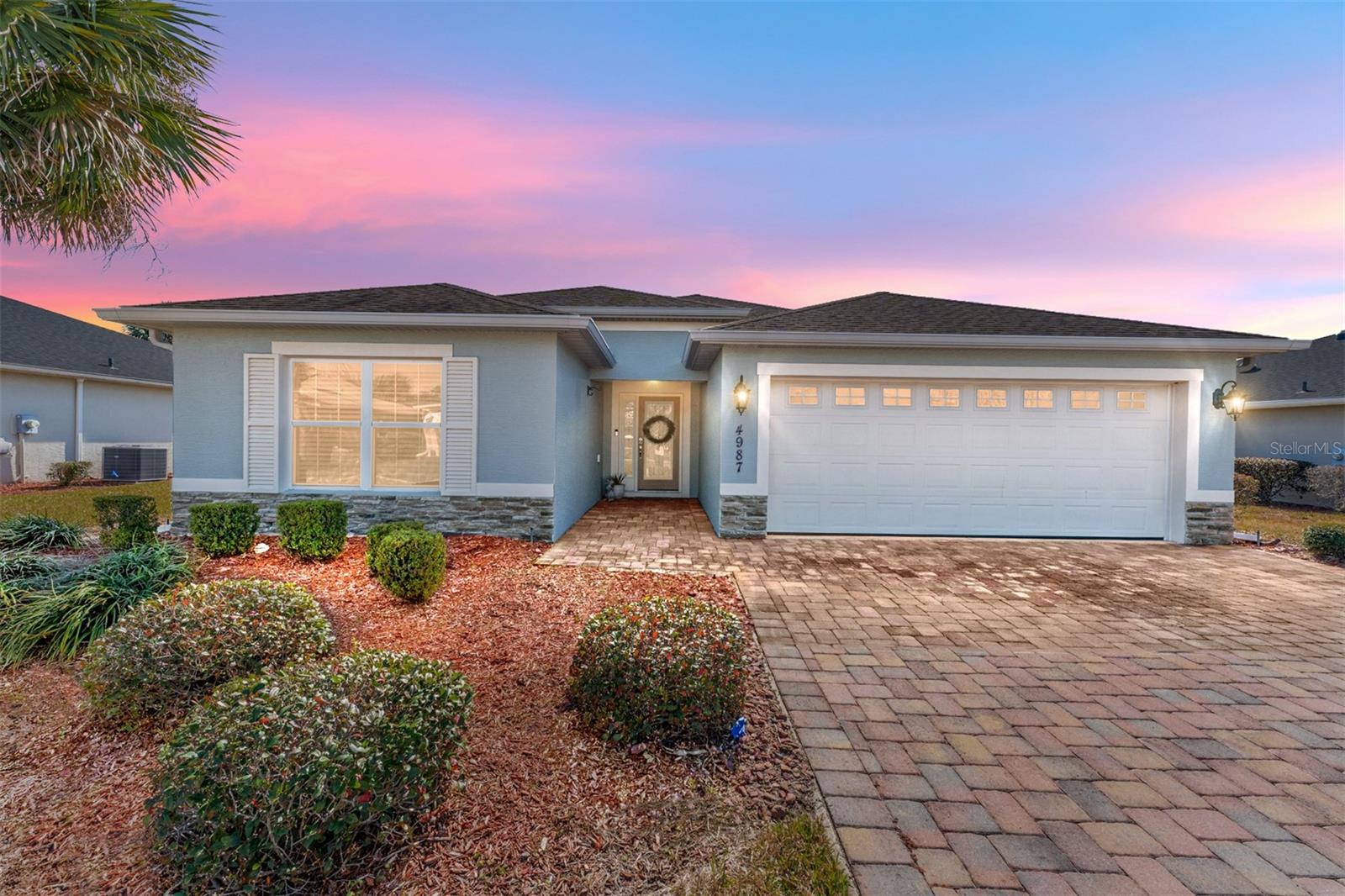 Immaculately maintained Flamingo Model home, situated in the highly sought-after Gated Community of Lakeside Landing's Enclave Subdivision which is ideally located in the area. Just a 12-minute golf cart ride to Sumter Landing, 15+ minutes to Spanish Springs, and less than 10 minutes to most of the conveniences in the area – several grocery stores, medical, dental, the new Home Depot, Lowes, and the future Costco and Target and so much more. The home welcomes you with its manicured lawn, STUCCO exterior, and PAVER driveway. Inside, you'll find an OPEN-CONCEPT, tile floors throughout the main living areas, and Luxury Vinyl Plank in the primary and the guest bedrooms. The kitchen has solid cabinets, QUARTZ COUNTERTOPS, STAINLESS STEEL APPLIANCES, and a breakfast bar that comfortably seats four, while the dining room provides additional space for hosting gatherings. The ample SPLIT GUEST ROOMS share a guest bathroom and linen closet providing privacy for you as well as your guests. The spacious primary bedroom spoils you with its luxurious en-suite bathroom with dual sinks mounted on QUARTZ COUNTERTOPS, complete with a tiled ROMAN SHOWER primary shower and TWO WALK-IN CLOSETS. Enjoy outdoor living with a private backyard in your spacious lanai that has been extended with a birdcage and HOT TUB. A separate laundry room ensures comfort and convenience, and the 2-car garage offers ample space for your golf cart and other personal vehicles. Locking garage door screen for comfort when working in the garage. If all these extras weren't already enough the HOA takes care of exterior pest treatment, lawn care, irrigation, and trash pickup, ensuring a carefree lifestyle. This is a TRULY GATED COMMUNITY featuring impressive wrought iron gates, boasting two pools including a relaxing RESORT-STYLE POOL, two in-ground Jacuzzis, a clubhouse with a library, billiard room, a FULL FITNESS CENTER, space for community events, a card room, putting greens, playground, basketball, tennis, and pickleball courts exclusively to residents. If you enjoy kayaking and sunshine you will love the access to Lake Miona. NO BOND. ROOF and HVAC 2017.