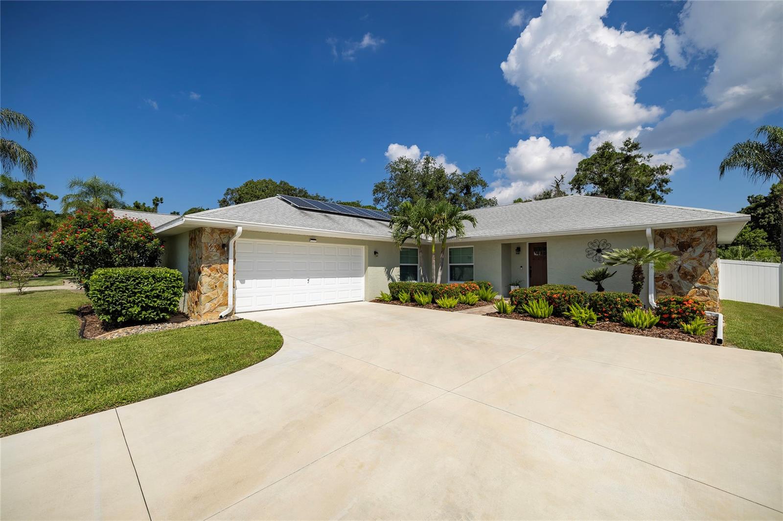 Pride of ownership is defined by this home! Step inside and feel "at home" from the freshly-laid flooring all the way up to the newly refinished ceiling -- The open floor plan is perfect for entertaining, and the split bedroom provides privacy to the Master Bedroom. New Luxury Vinyl flooring connects all living areas to the Master Bedroom, and fresh carpet is laid in the other 2 cozy Bedrooms. The updated Kitchen is large and open, and has newer Stainless-Steel Appliances and Granite Countertops. It features 2 closet pantries for both groceries and small appliance storage! The Kitchen overlooks the large Family and Dining Rooms, and provides a beautiful setting for big family gatherings! The pool area has also been completely redone -- it is like NEW! New pavers surround the pool, the pool cage has been reinforced and re-screened and has new screen doors, the sunning patio is built from new pavers, and the pool has been resurfaced. All pavers were resealed in 2024! The pool heater was replaced in 2020, and the Pool Pump and Filter are also newer 2018. The Roof is newer 2017, Solar Panels are 2016, all new fascia, soffits and gutters in 2018, and so much more!! Feel safer than ever in this Flood Zone X home that is equipped with Hurricane windows and Slider (2018). Having NO BACK NEIGHBOR, this home provides the most private back yard offered for sale right now! Wooded views with beautiful landscaping, and an adorable little creek all run behind this home. The property line extends just past the pool screen, yet it feels as though your property line never ends! Freshly painted inside and out, an entire new driveway laid in 2023, a new water softener/filtration system --- The updates are ENDLESS – Ask your Realtor for the list of every upgrade and home improvement! The location can't get any better-- Clearwater pricing with Palm Harbor value! Only a 5-minute drive to reach endless shopping, dining, AMC Classic movie theater, and so much more! Only a 30-minute drive to Tampa Int'l Airport, under 20-minute drive to PIE Airport, a 15-minute drive to Honeymoon Island, and easy access to ALL major roads from within this peaceful and quiet neighborhood. Walking Access to Forest Run Park is located right down the street, for safe travels to the playground and walking trails! Does it get any better? Make your appointment today!! **The charming little creek and bench area behind the home has been maintained by the Seller, but is owned by the City of Clearwater.**