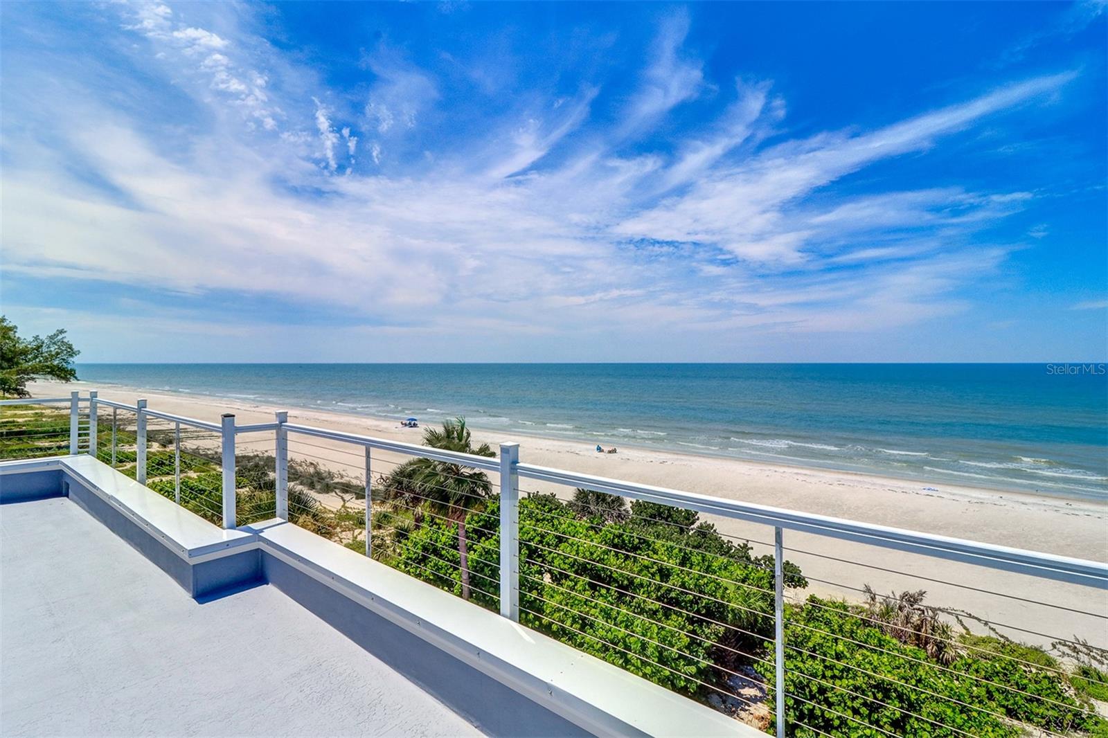 Direct beachfront luxury home in Indian Rocks Beach. Experience modern coastal living in this exceptional single-family home in the highly sought-after Indian Rocks Beach. Built in 2022, this contemporary masterpiece combines striking design, quality construction, and breathtaking views, offering an unparalleled Florida lifestyle. This spacious 4-bedroom, 5.5-bathroom residence boasts over 5,500 total square feet, 3,870 square feet under air, with solid block construction and storm-rated tinted windows and doors for energy efficiency and turtle protection. A 3-car tandem garage accommodates up to six vehicles. Step outside to your own private paradise with a beachfront heated swimming pool and hot tub, expansive lounge deck with sun chairs, picnic tables, and BBQ grill, and a private path with direct access to the sugar-sand beach. Inside, a custom double-door entry with etched glass tropical artwork welcomes you into a grand foyer with elevator access to all four levels. The main living level offers a coastal-elegant ambiance with floor-to-ceiling windows framing epic water, beach, sunrise, and sunset views. Driftwood-inspired plank tile flooring flows throughout. The gourmet chef’s kitchen is a dream with a large island with seating, premium Thermador stainless steel appliances, built-in double ovens, cooktop range and hood, full-size wine refrigerator, custom wood cabinetry, white with gray veined quartz countertops, intricate tile backsplash, and designer pendant lighting. Both the kitchen and living area open to a spacious balcony overlooking the pool and beach. This level also features a guest ensuite bedroom, powder room, and laundry/mechanical room. The third level hosts the luxurious beachfront primary suite with a sprawling balcony, spa-inspired bathroom with a free-standing soaking tub, custom tile shower with glass enclosure, and a walk-in closet with custom built-ins. Two additional en-suite bedrooms, each with designer baths, share a hallway featuring a stylish wet bar with sink, mini-fridge, and stone countertops. The top floor offers a unique loft-style studio complete with a kitchenette, queen-size pullout sofa, full bathroom, and two sliding doors leading to a rooftop terrace with 360-degree panoramic views of the Gulf and beyond. Perfect as a primary residence, vacation retreat, or high-income investment property, this home has no minimum rental restrictions and comes fully furnished with elegant coastal décor, turnkey and ready to enjoy. Located within walking distance to charming shops, boutiques, restaurants, and pubs, with convenient access to Clearwater Beach, major bridges, and two international airports, enjoy world-class fishing, snorkeling, paddle boarding, boating, or simply unwind on the beach with a cold drink as the sun sets over the Gulf.