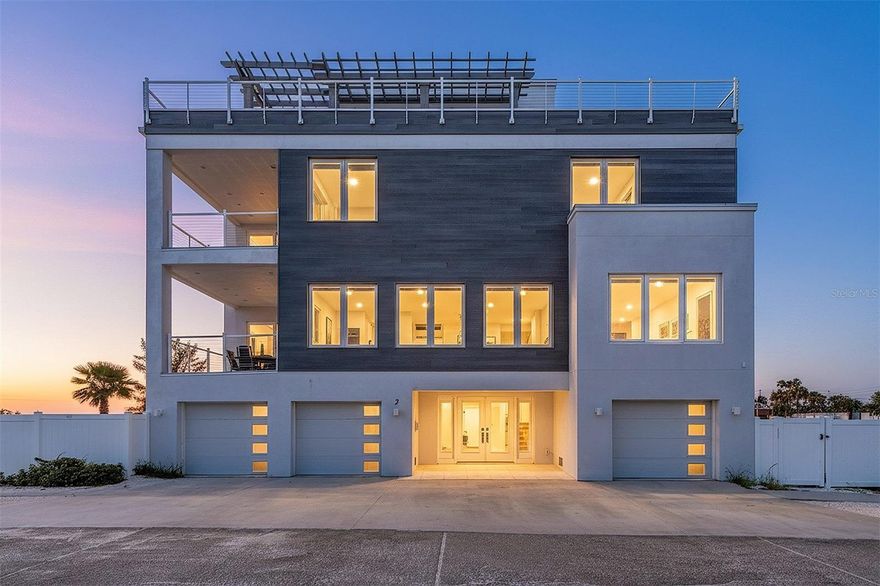 Direct beachfront luxury home in Indian Rocks Beach. Experience modern coastal living in this exceptional single-family home in sought-after Indian Rocks Beach. Built in 2022, this contemporary masterpiece combines striking design, quality construction, and breathtaking views, offering an unparalleled Florida lifestyle. This spacious four-bedroom, 5.5-bath residence boasts over 5,500 total square feet, 3,870 square feet under air, with solid block construction and storm-rated tinted windows and doors for energy efficiency and turtle protection. A three-car tandem garage accommodates up to six vehicles. Go outside to your private paradise with a beachfront heated swimming pool and hot tub, expansive lounge deck with sun chairs, picnic tables and barbecue grill, and a private path with direct access to the sugar-sand beach. Inside, a custom double-door entry with etched glass tropical artwork welcomes you into a grand foyer with elevator access to all four levels. The main living level offers a coastal-elegant ambiance with floor-to-ceiling windows framing epic water, beach, sunrise and sunset views. Driftwood-inspired plank tile flooring flows throughout. The gourmet chef’s kitchen is a dream with a large island with seating, premium Thermador stainless steel appliances, built-in double ovens, cooktop range and hood, full-size wine refrigerator, custom wood cabinetry, white with gray veined quartz countertops, intricate tile backsplash and designer pendant lighting. Both the kitchen and living area open to a spacious balcony overlooking the pool and beach. This level also features a guest bedroom with en suite, powder room, and laundry/mechanical room. The third level hosts the luxurious beachfront primary suite with a sprawling balcony, spa-inspired bath with a free-standing soaking tub, custom tile shower with glass enclosure, and a walk-in closet with custom built-ins. Two additional bedrooms with en suites, each with designer baths, share a hallway featuring a stylish wet bar with sink, mini-refrigerator and stone countertops. The top floor offers a unique loft-style studio complete with a kitchenette, queen-size pullout sofa, full bath, and two sliding doors leading to a rooftop terrace with 360-degree panoramic views of the Gulf and beyond. Ideal as a primary residence, vacation retreat or high-income investment property, this home has no minimum rental restrictions and comes fully furnished with elegant coastal décor, turnkey and ready to enjoy. In walking distance to charming shops, boutiques, restaurants and pubs, with convenient access to Clearwater Beach, major bridges and two international airports, enjoy world-class fishing, snorkeling, paddle boarding, boating, or simply unwind on the beach with a cold drink as the sun sets over the Gulf.