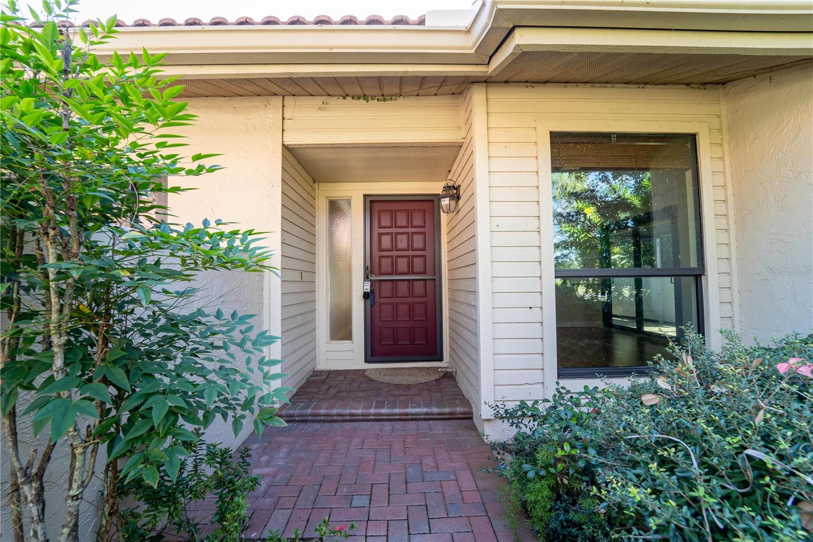 Nestled in an ideal, quiet location on a large, private corner lot, this beautifully maintained Carriagehouse II offers maintenance-free living with an expanded footprint and a host of exceptional features. Enjoy the luxury of two lanais: a fully enclosed, air-conditioned lanai spanning the full width of the home, perfect for year-round use, and a second large, screened outdoor lanai ideal for relaxing and entertaining. All exterior windows and sliding doors have been upgraded to PGT WinGuard systems for enhanced durability and energy efficiency. The home boasts a complete tile roof replacement in 2005, complemented by custom gutter guards for a truly maintenance-free exterior. Inside, the kitchen and both bathrooms have been tastefully remodeled, showcasing modern finishes and thoughtful design. The kitchen features a convenient pass-through that opens to the spacious dining area and living room, complete with a cozy wood-burning fireplace. Located within The Landings, a prestigious 24-hour gated community, you'll enjoy serene lakes, greenbelts, and a boardwalk leading to the Intracoastal Waterway. This prime location is just minutes from downtown Sarasota, Siesta Key Beaches, and nearby shopping. This Carriagehouse stands out with its private outdoor space, surrounded by mature landscaping, a secluded corner lot, and an attached single-car garage with additional private guest parking. Community amenities include a large pool, spa, and clubhouse just steps away. Optional membership to The Landings Racquet Club adds even more value, offering access to 8 Har-Tru tennis courts, a temperature-controlled pool, hot tub, fitness center, library, and vibrant social activities. Experience the perfect blend of privacy, luxury, and convenience in this stunning Carriagehouse. Don’t miss this rare opportunity to call The Landings home!