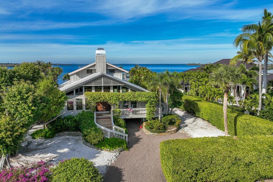 Adorned by a majestic Ficus tree and surrounded by mature landscaping, this waterfront home is nestled on approximately 100' lot in the community of Boca Grande Isles. Built in 1988, this unique home offers 4 bedrooms, 4 baths with serene water views of Sunset Flats and Gasparilla Sound. The tropical landscaped yard leads to the elevated main level offering an open floor plan with vistas of the pool and waterfront. The soaring open rough-hewn beam ceiling in the main living area are accented by pecky cypress walls, plantation shutters and wood flooring. The kitchen is equipped with granite counters, stainless steel appliances and a breakfast area with a wall of windows with stunning water views. The upper-level waterfront primary bedroom suite is a true retreat and overlooks the pool area. The lower-level pool side of the home offers two private en-suites with provide comfortable accommodations for family and visitors. The oversized above ground pool with large decking is easily found through multiple access points to outdoor entertaining. Experience waterfront living and make this you own piece of paradise. This home has potential for remodeling or tear down to build you dream house on Boca Grande Isles.
