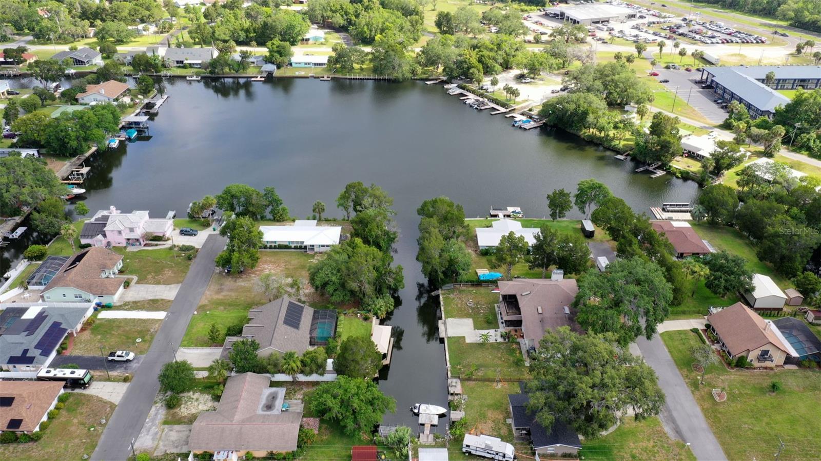 Never flooded - a few inches in garage during storm Helene. Elevation certificate available! Enjoy the waterfront experience & own a home situated on elevated grounds, no stairs to climb! Outstanding residence presents an excellent opportunity to have it all: updated from the roof (2023), A/C (2024); eat-in kitchen with white cabinets, stone countertops & SS-appliances; the primary bathrooms has a jetted tub and modern glass enclosed shower; tile & Pergo floors, to the pavers around the house and pool. Listen to the sound of the fountain from your deck, overlooking the water! Nicely landscaped, the backyard is fenced for pets. There is ample room on the dock, the covered boat lift accommodates vessels up to 7,000 lbs. Hobby enthusiasts will love the workshop & shed. Newly painted inside & out and meticulously maintained this home is truly move-in-ready. And the cherry on top: the home is not within city limits – short-term rentals are allowed!!