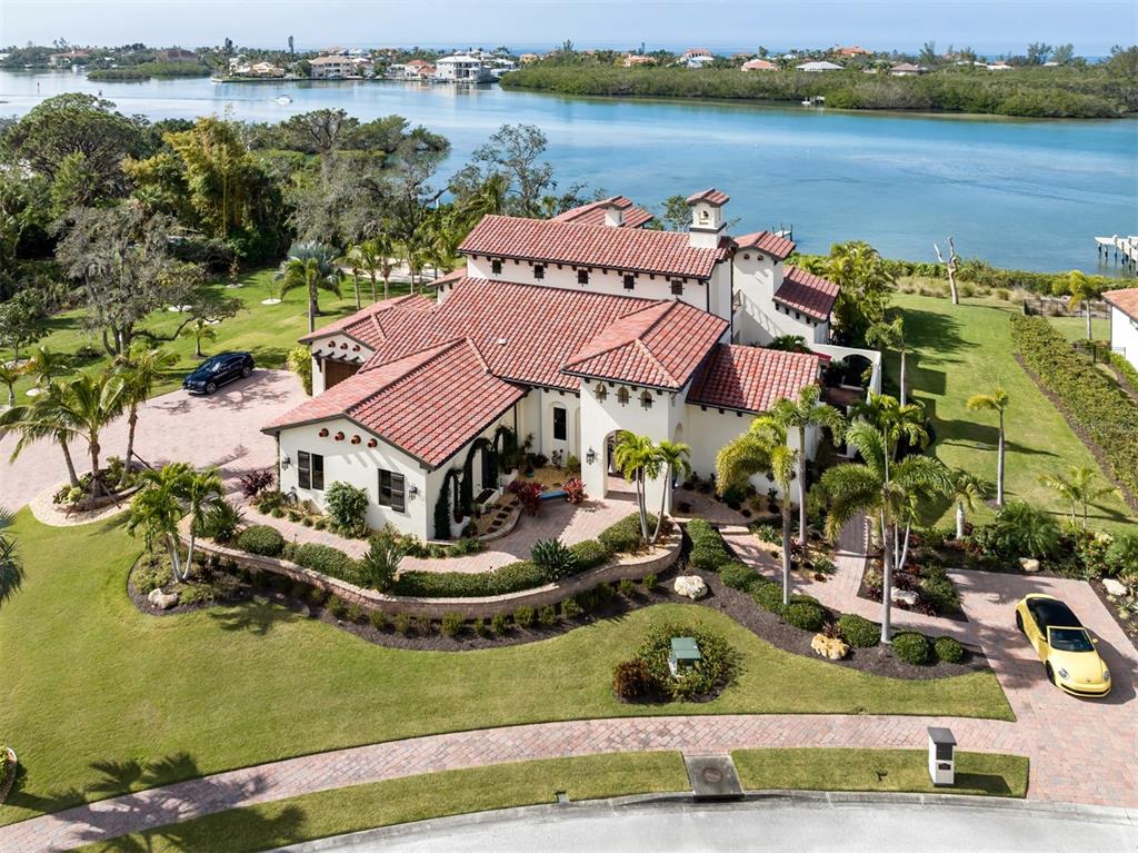 This incredible property went under contract within the first week it came to market. Due to unforeseen circumstances for the buyer we are back on the market. TRULY A STORYBOOK WATERFRONT ESTATE on Sarasota's Blackburn Bay. Built by the developer of the community for his own family, this incredible Bayfront estate spans 4 lots and more than 1.5 acres of waterfront property and nearly 5,000 sq. ft.of extraordinary living space. Every so often a property comes to market that is quite simply one-of-a-kind. This is one such estate. From the moment you approach, you'll be impressed by sensational and thoughtful landscaping that leaves no part of this property unfinished. From Tropical fauna, to delicate flowers and succulents placed creatively throughout the yard your senses will delight at every turn. The walled morning herb & flower garden area and the newly planted orchard can be enjoyed from the kitchen window and the private sitting area outside. As captivating as the grounds are, the residence defines excellence and offers dramatic appeal from the moment you enter. Incomparable materials, outstanding craftsmanship, breathtaking water views, and exceptional patios and pool area will overwhelm your senses. Upon entry you eyes move to the brick barreled ceiling, exquisite flooring, and architectural details. An impressive Gathering Room is highlighted by the dramatic oversized fireplace and sits adjacent to the equally incredible outside entertaining space with another natural fireplace. The spa and pool area highlight the backdrop of turquoise waters of the bay beyond. A separate and elegant Guest Casita sits to the side of the pool area and is complete with full ensuite and impeccable finishes. Behind the Casita and convenient from the main house is another private outdoor dining/entertaining garden patio. Back inside you find a spectacular gourmet kitchen with top-tier appliances, stunning custom granite, black walnut island, and a stellar walk-in pantry that will be the envy of every master chef. A tasteful owner's retreat defines the left side of the residence with enormous walk-in closets including private washer & dryer built in, a dramatic bathroom suite and a separate dressing and make-up room. Additional property highlights include a media room/guest suite upstairs, private large office, and another full bath. An air conditioned 3 car garage is attached to the home, with another large 2+ car garage on property located next to the private and completely redone Pickle Ball Courts. Ask about the incredible 40' boat rackominium that can be purchased separately to accomodate your boat at the nearby marina! This is incomparable waterfront living on Sarasota's Blackburn Bay with a location that sets the stage for a lifetime of extraordinary memories. View by Private Appointment Soon! Property being sold completely furnished. (HOME CAN EASILY ACCOMMODATE UP TO 5 BEDROOMS with minor adjustments.)