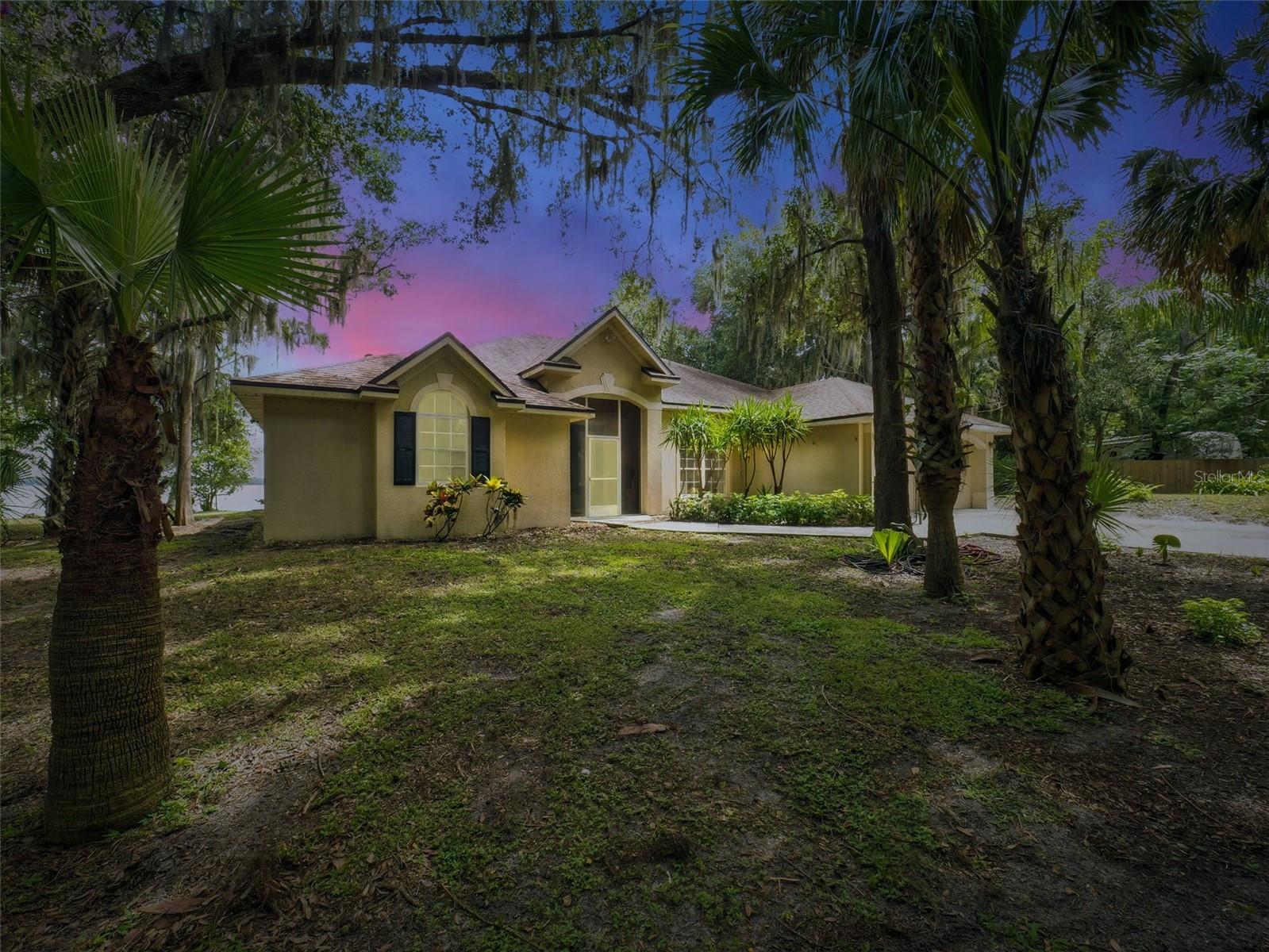 Discover your own slice of hidden paradise with this one-of-a-kind opportunity. Situated on almost one acre (NO HOA), this spacious 3Bdrm/2Bath home offers an open floor plan with high ceilings, filling the living spaces with natural light and breathtaking panoramic lake views. With a split-bedroom layout for added privacy, this home seamlessly blends comfort with versatility. Step outside to an oversized screened porch, the ideal spot to unwind, savor tranquil sunsets, and watch nature unfold across the sparkling waters. An added bonus is the flexibility provided by a large detached garage/building, offering endless possibilities—create a private office, guest house, apartment, or studio tailored to your needs. Indulge in the tranquil lifestyle of waterfront living from your very own backyard. The lot’s private setting ensures peace and relaxation, yet you’re only minutes from local shopping, dining, entertainment, and convenient access to 417. If you’re seeking breathtaking sunsets, extraordinary lakefront views, and unlimited potential in the heart of Sanford, this one-of-a-kind property invites you to make your lakeside living dream a reality.