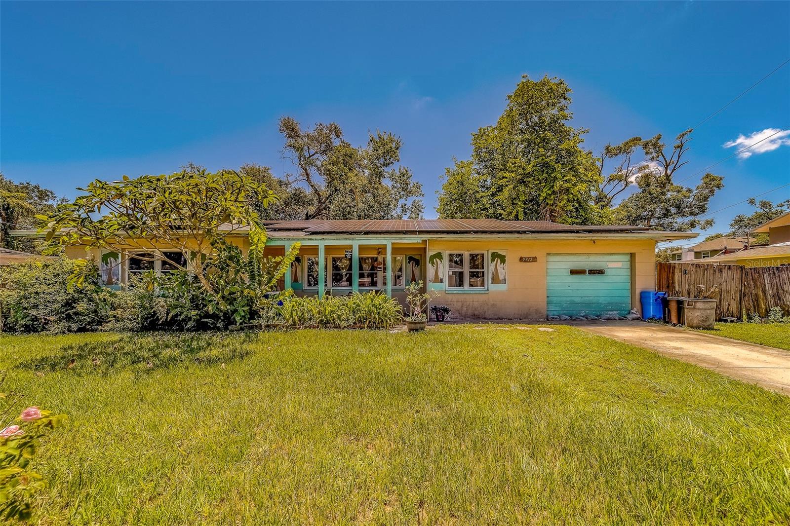 Come take a look at this 2 bedroom, 1 bath, 1 car garage home that features a HUGE BONUS ROOM 16X28 IN SIZE. The bonus room is currently being used as a third bedroom and is air-conditioned, or could also be used as an office/workout room or a craft room. Endless possibilities. The roof was replaced in 2019, and SOLAR PANELS were installed at that time as well. AC was replaced in 2020. Home has double-pane windows and terrazzo flooring. Large backyard and plenty of greenery adorn this lot. There is also alley access on the west side of the lot. Close to shopping, restaurants, parks and the wonderful Gulf Beaches. Home is being sold "AS IS" for seller's convenience. Don't delay and make your appointment today!!!