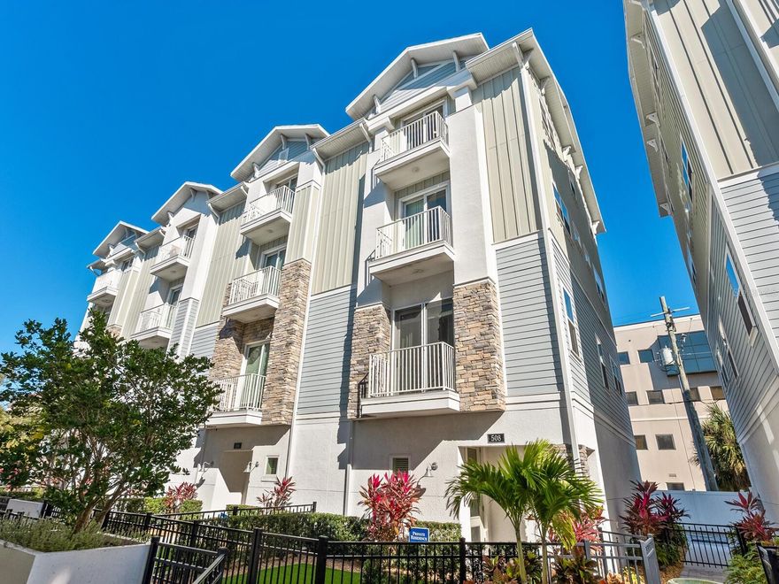 It’s always about the experience of living downtown Sarasota from this 4 story townhome with elevator for convenience. Built to rigorous standards with impact windows and doors. Charming gated entry to home, makes it very inviting and to the foyer, where a private elevator provides access to every level of the home. First level with private 2 car garage, oversized closet. Second level hosts the kitchen and open great room concept dining and living area. Also, an easily accessible powder room.  Third level offers 2 spacious ensuite bedrooms with walk in closets. Topping it all off, on the entire 4th level is a grand owner’s suite with Walk in closet, spa bath and thoughtful bar area with beverage fridge. Each floor/area of the residence has dual balconies for seamless indoor/outdoor living. The kitchen has on point cabinet color with quartz counters, stainless appliances and induction cooktop with down-draft venting. Hardwood floors throughout the main living areas provide warmth and sophistication. This idyllic downtown location in the Enclave at Laurel Park is walking distance to the Bayfront Park, Ringling Bridge, Farmers Market, the Sarasota Opera, Van Wezel, fine dining, shopping, and all that bustling Sarasota offers. Payne Park with tennis, playground, skate park are nearby as well as an extraordinary beach and boating lifestyle. Siesta Key and Lido Beach are moments away as is Legacy Trail and access to many parks and preserves.  This truly extraordinary home is the perfect frame for an exceptional easy living life!